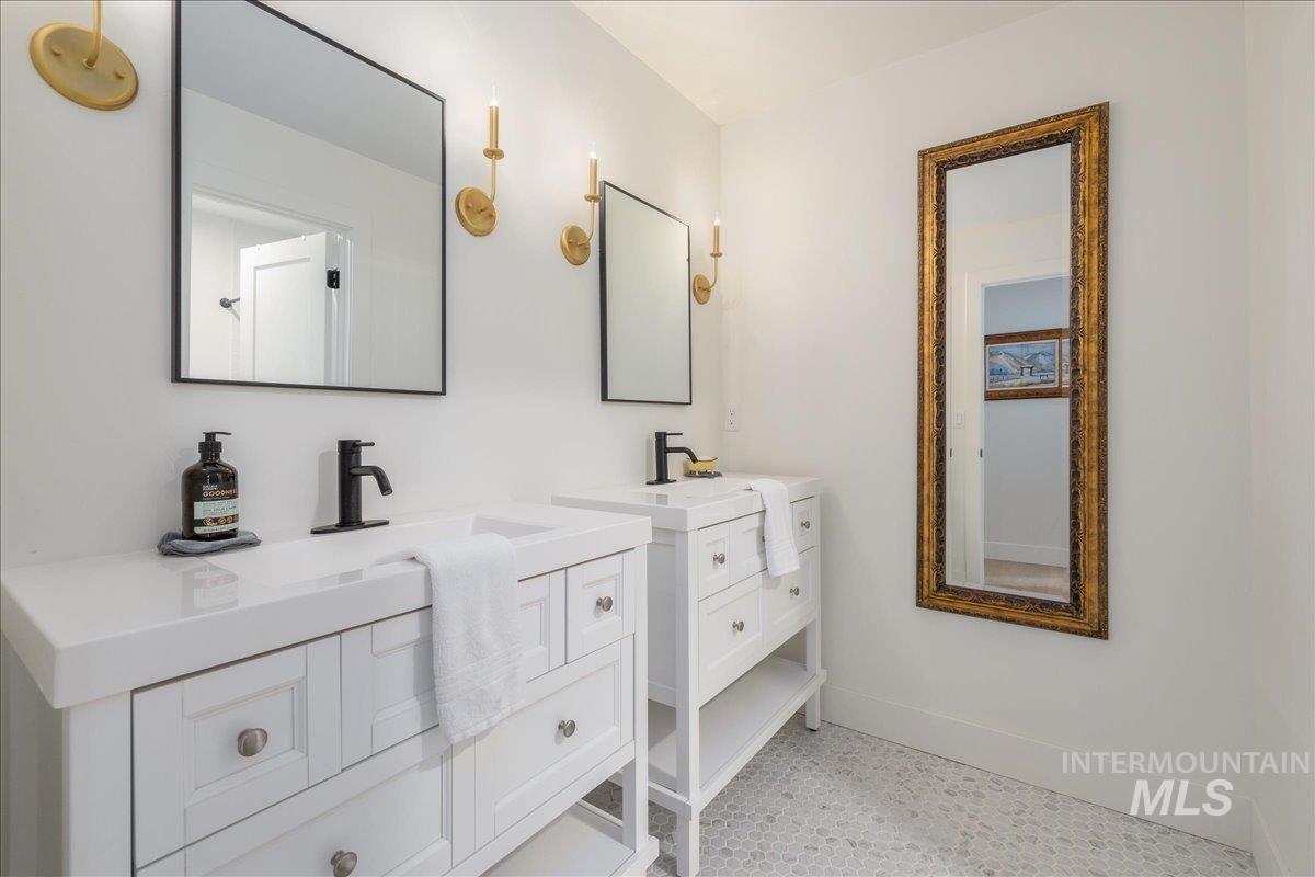 Full bathroom with two vanities and baseboards