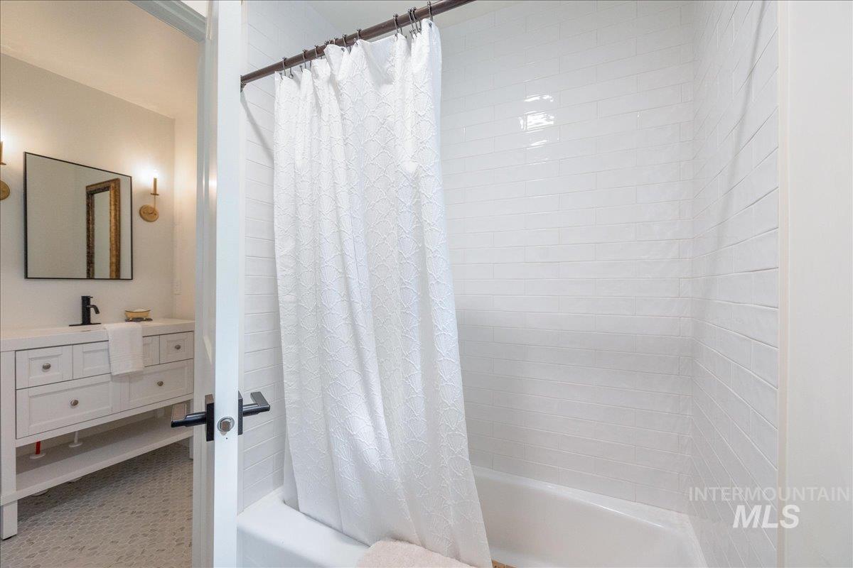 Full bath featuring shower / tub combo with curtain and vanity