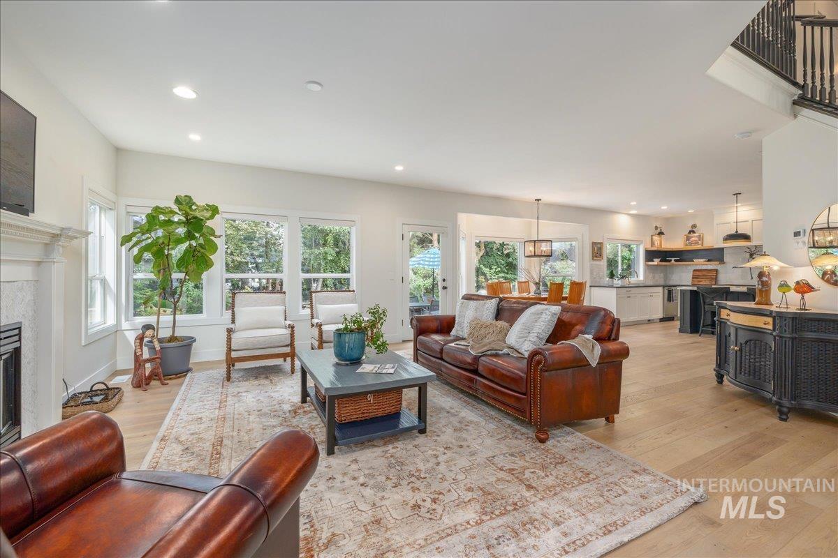 Living room featuring light wood-type flooring, recessed lighting, and a glass covered fireplace