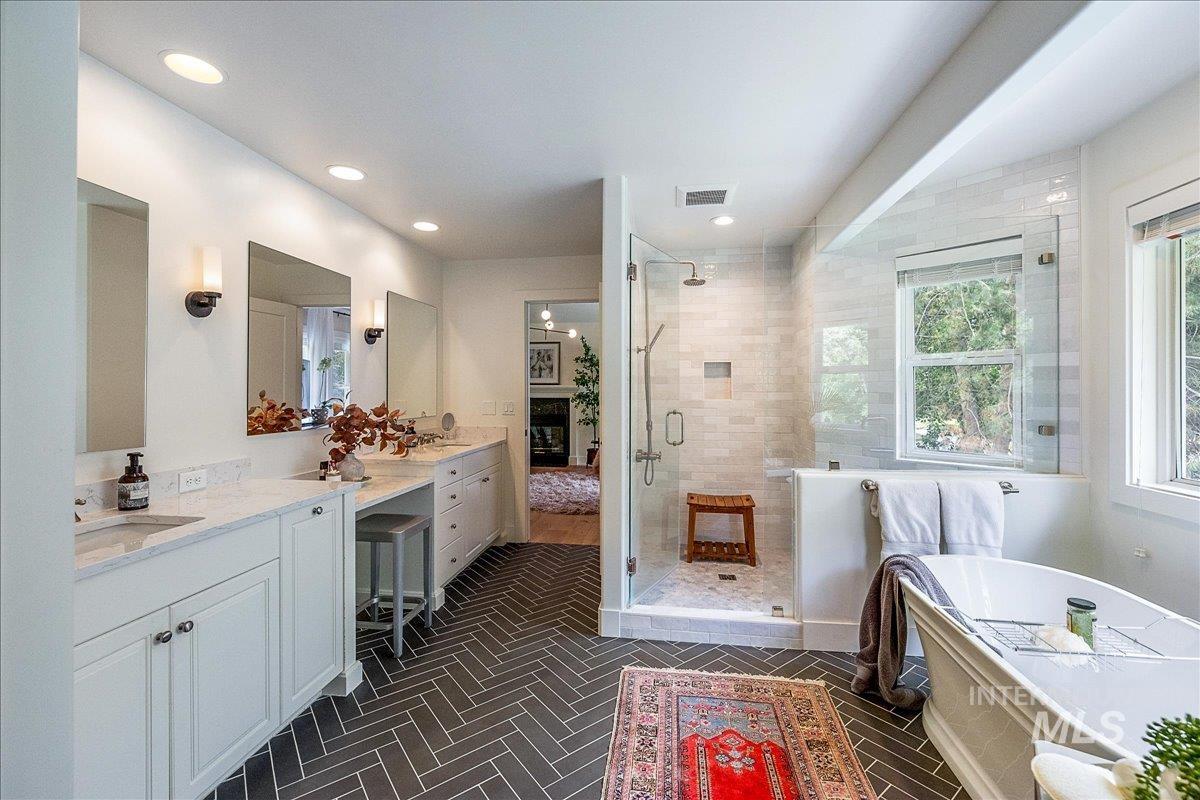 Bathroom with a freestanding tub, a shower stall, vanity, and recessed lighting