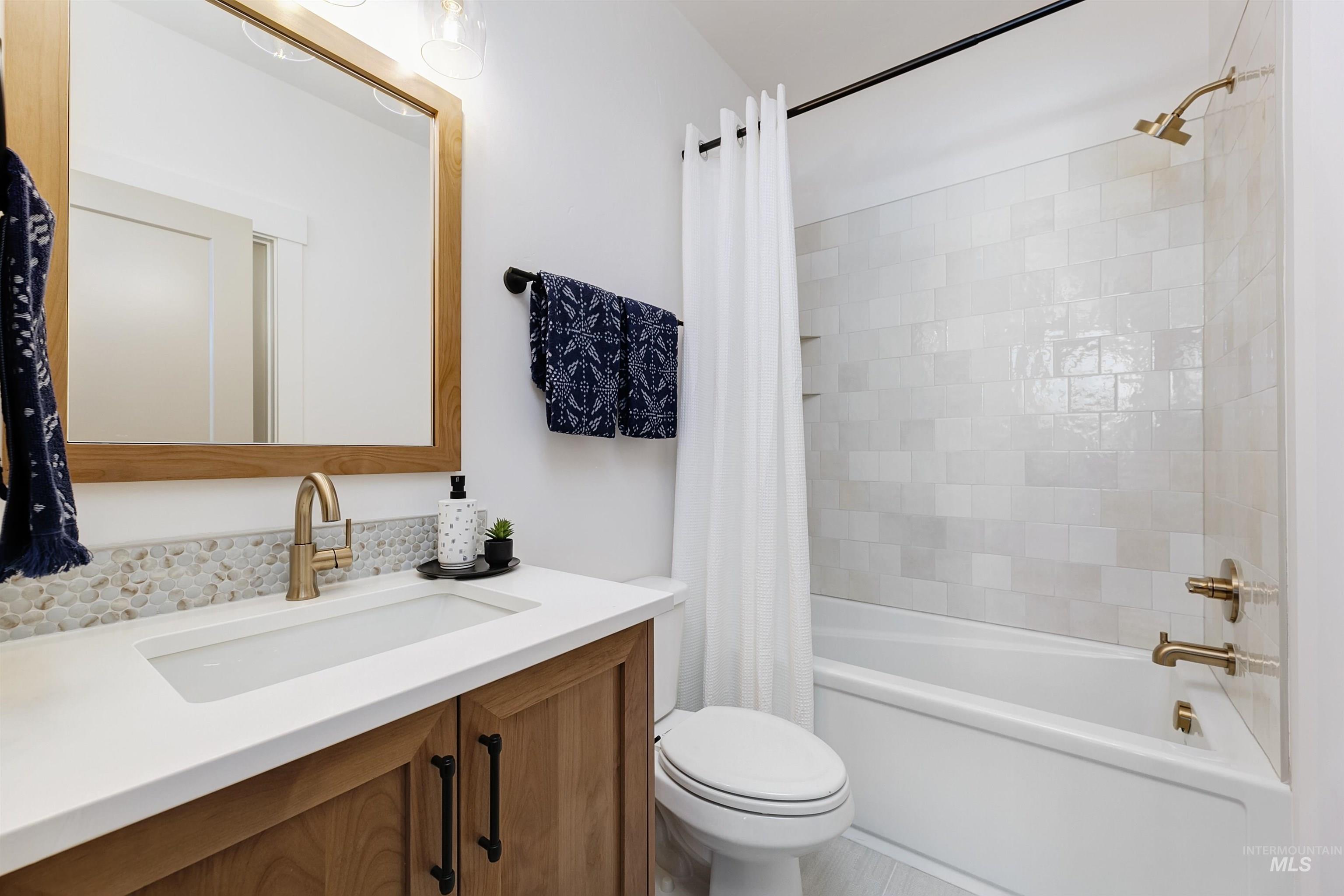 Bathroom featuring shower / bath combo with shower curtain and vanity