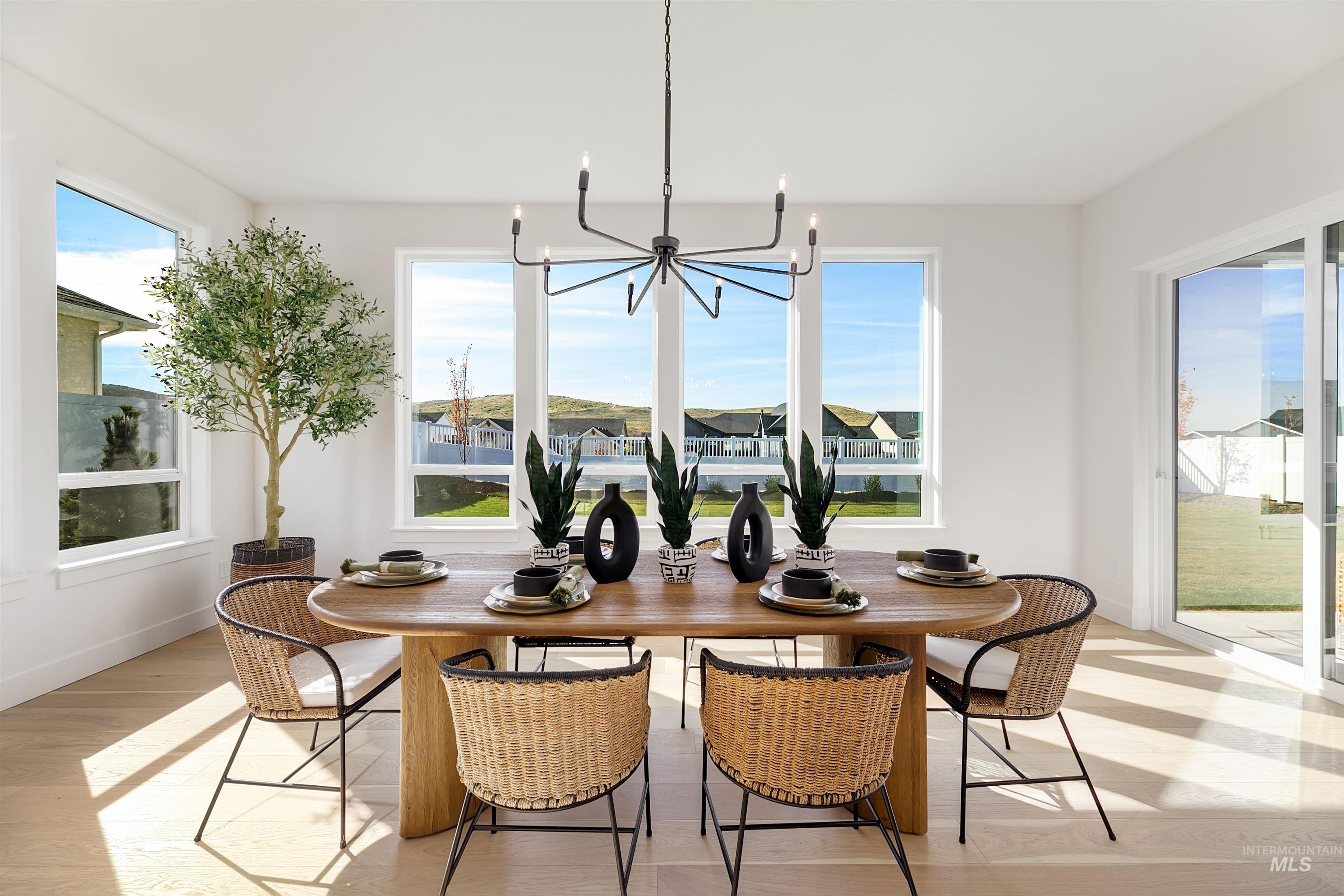 Dining space with light wood-type flooring and a chandelier