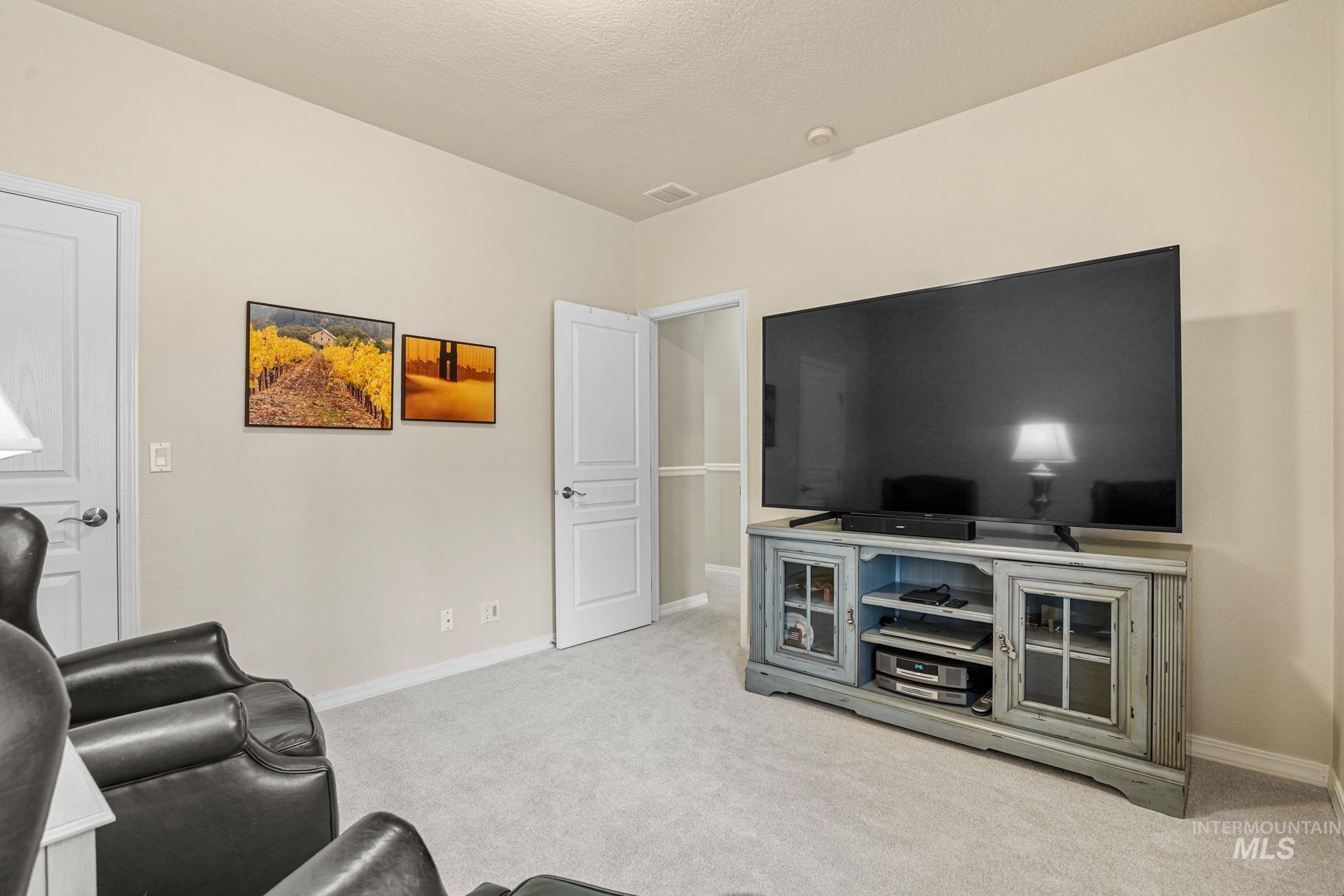 Living room with light colored carpet and baseboards