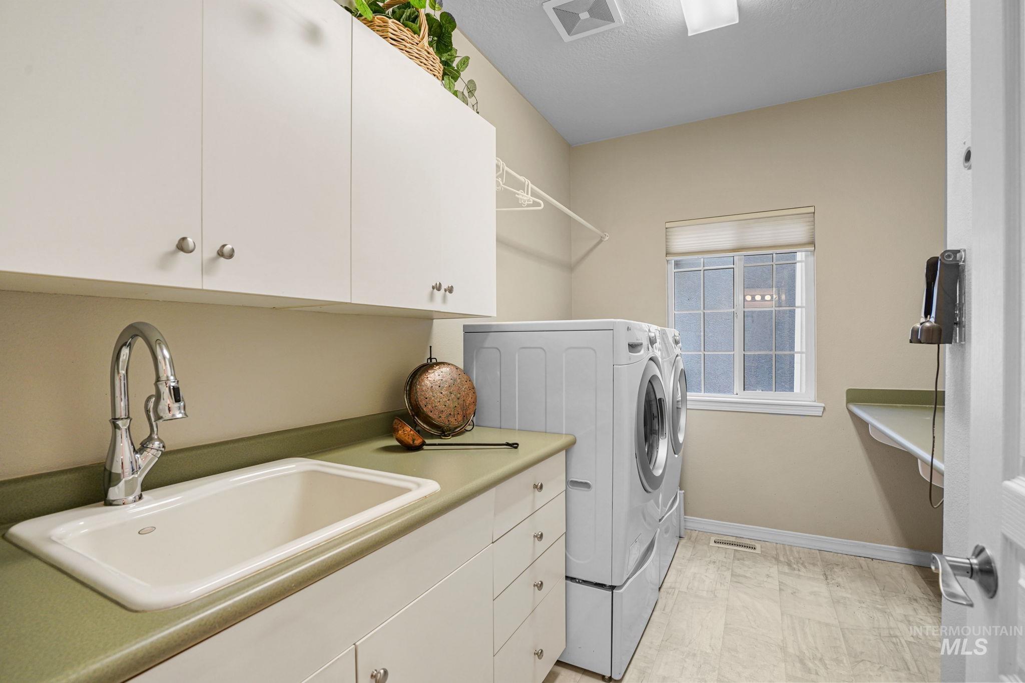 Laundry area featuring cabinet space, separate washer and dryer, and a textured ceiling