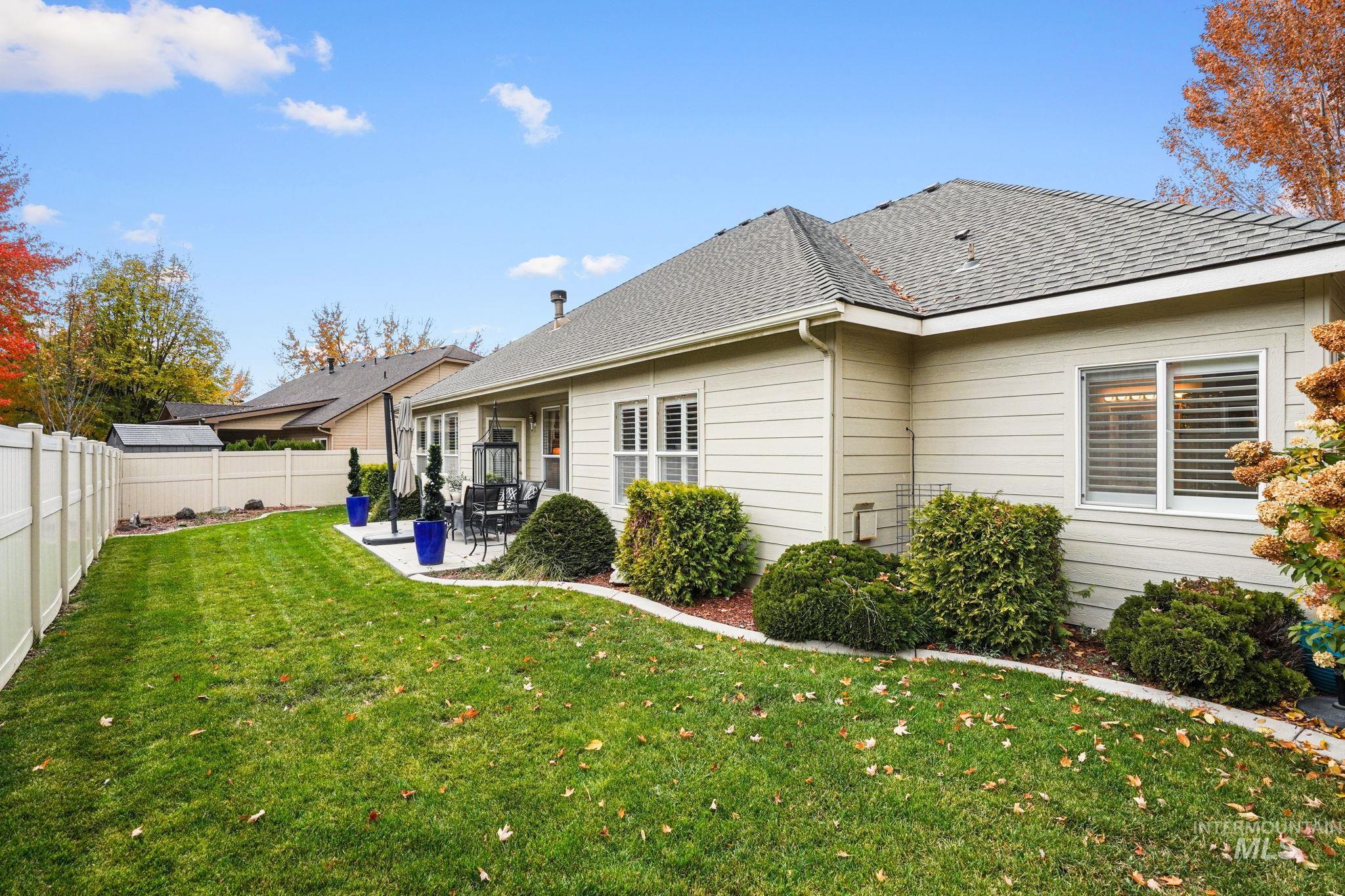 Rear view of property with a shingled roof, a patio, and a fenced backyard