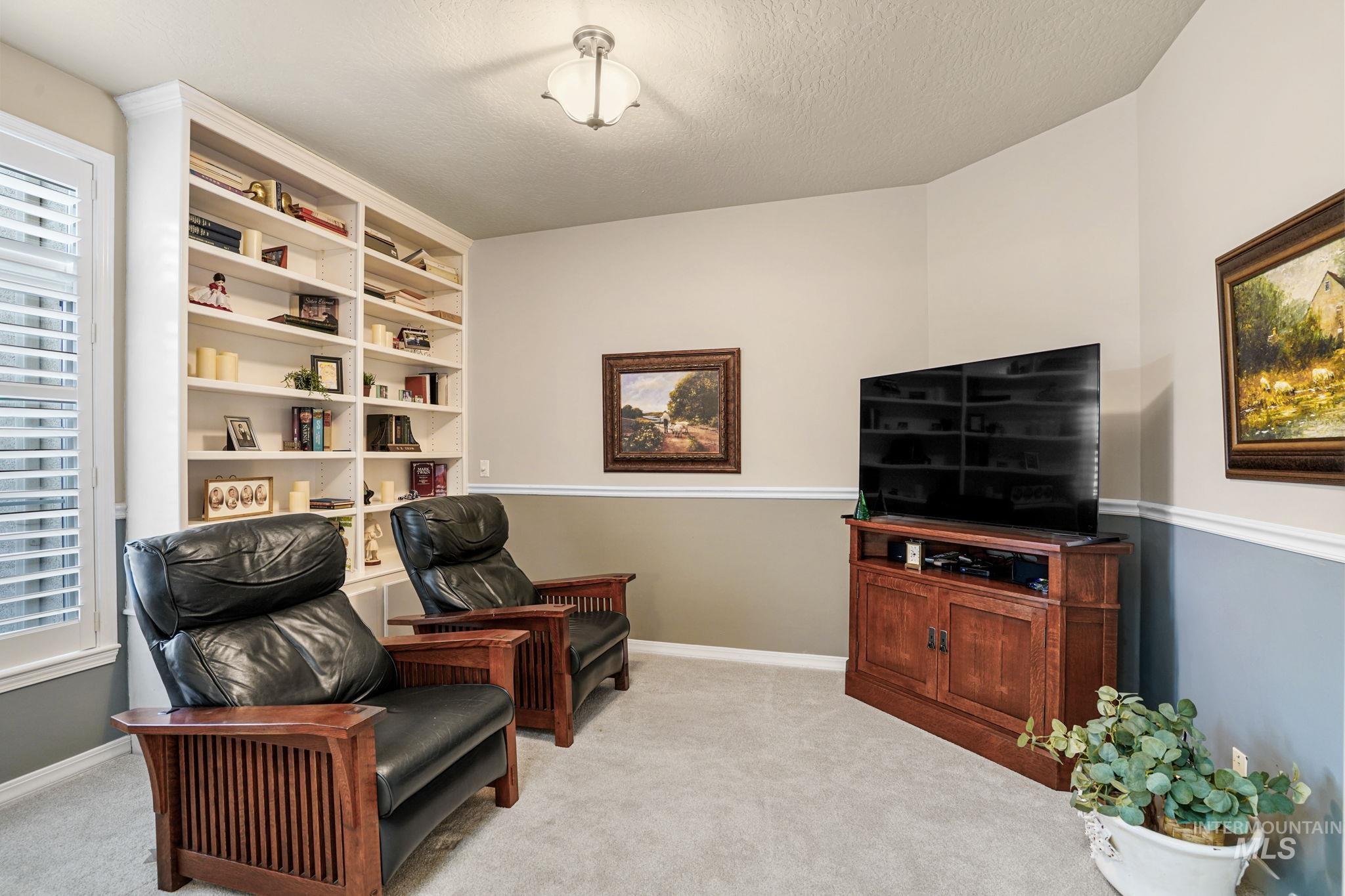 Living area featuring light colored carpet and a textured ceiling