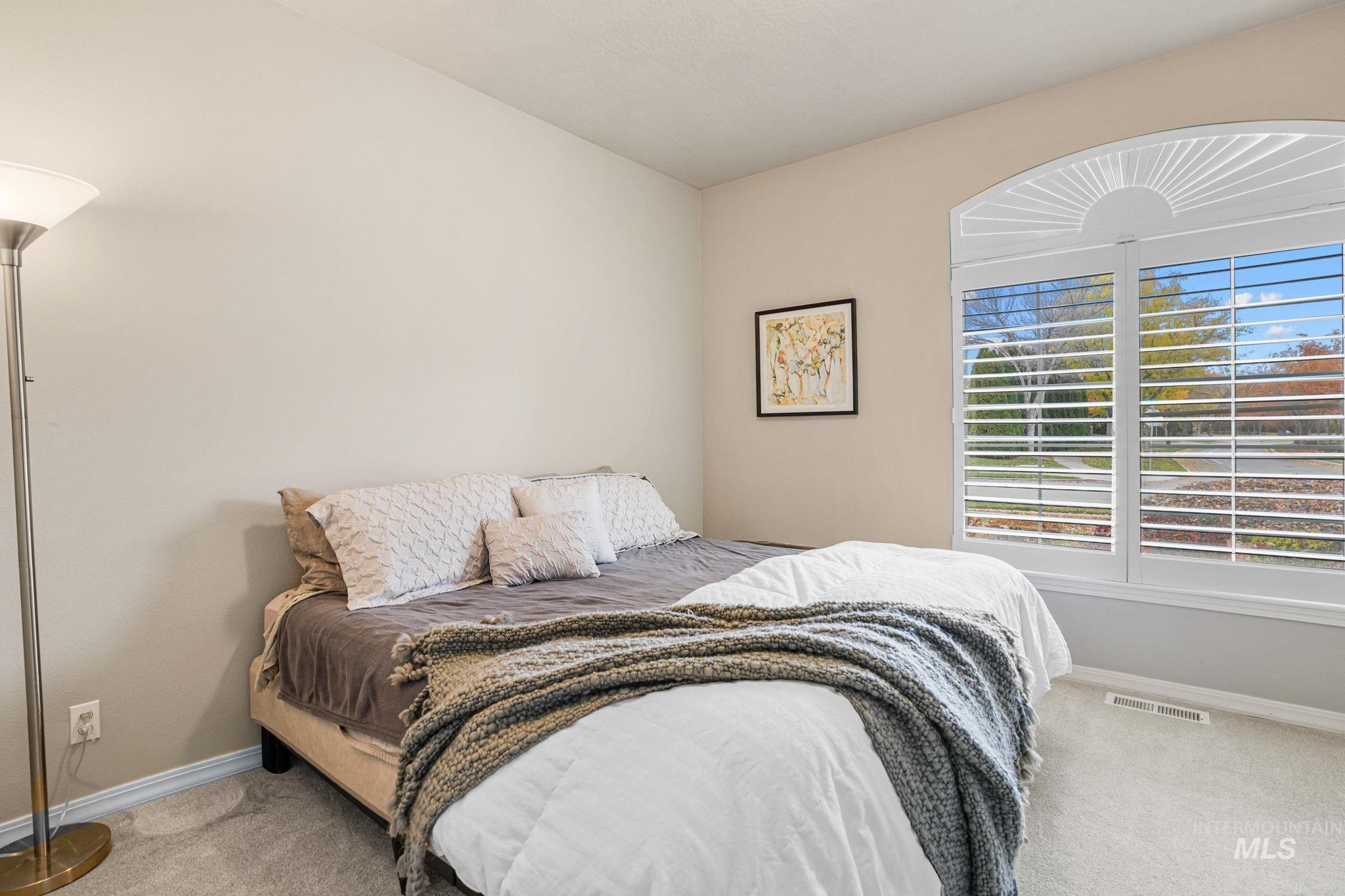 Bedroom with light colored carpet and baseboards