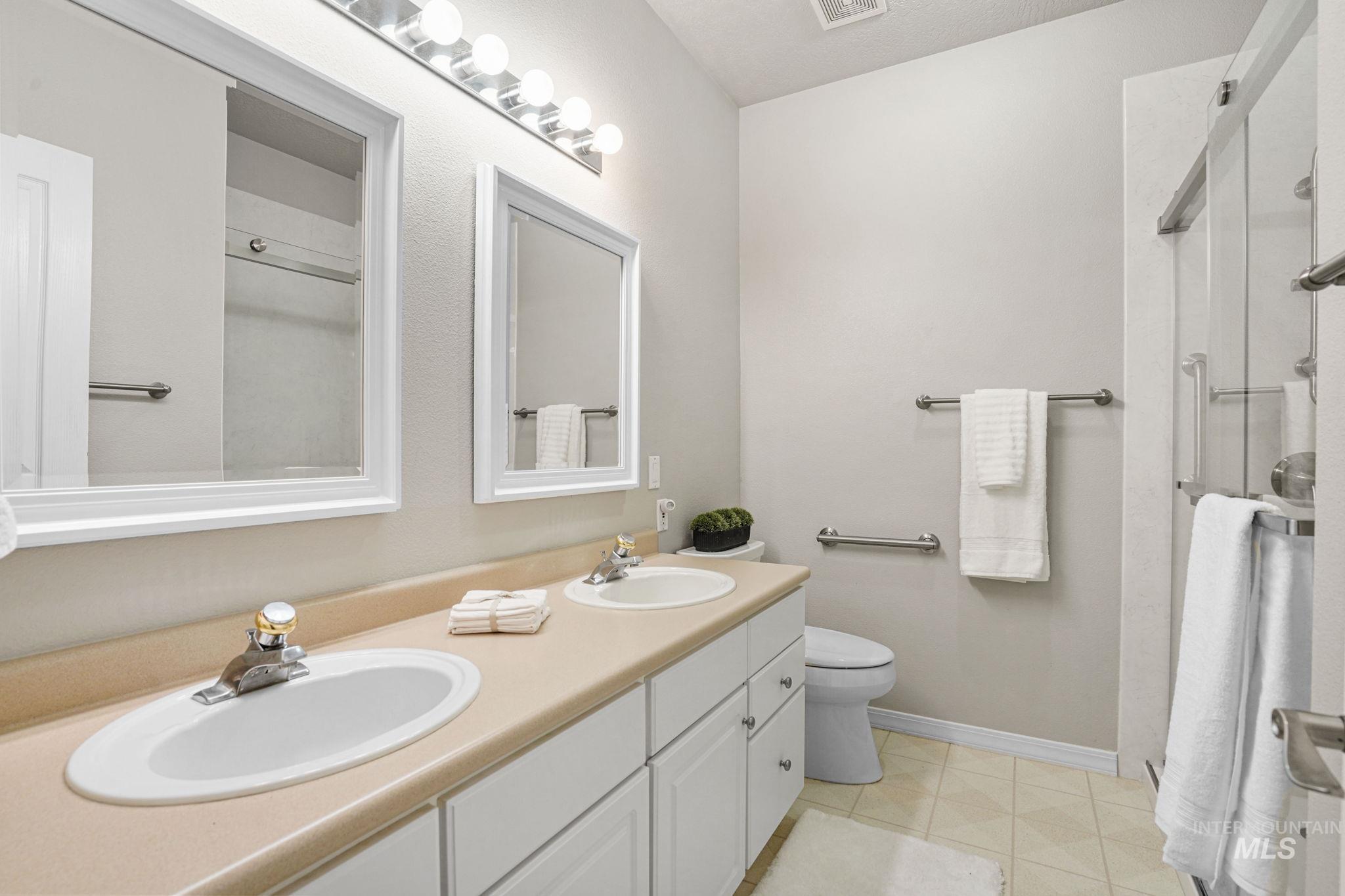 Bathroom featuring double vanity and a shower with shower door