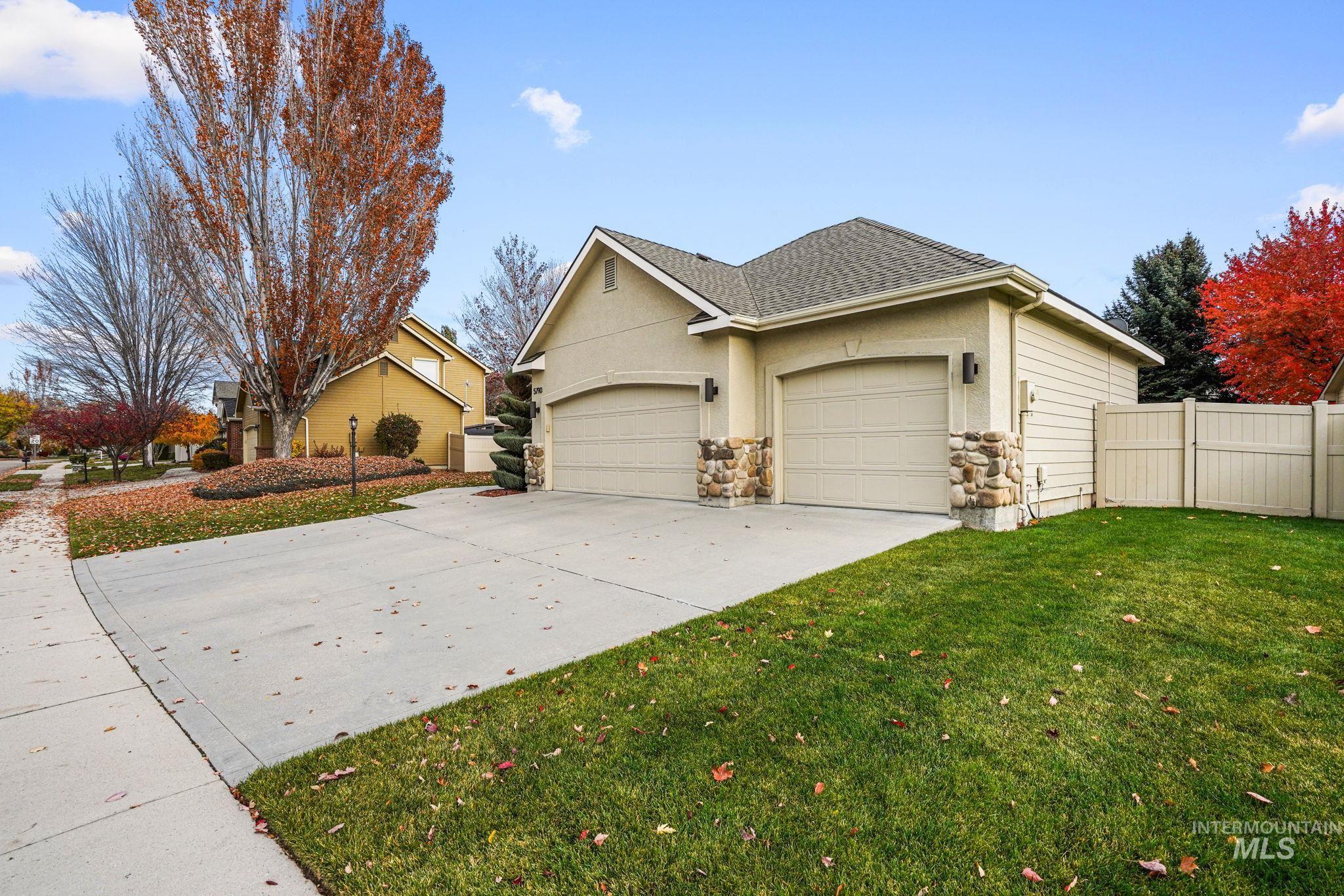 View of front of home with a shingled roof, concrete driveway, an attached garage, stucco siding, and stone siding