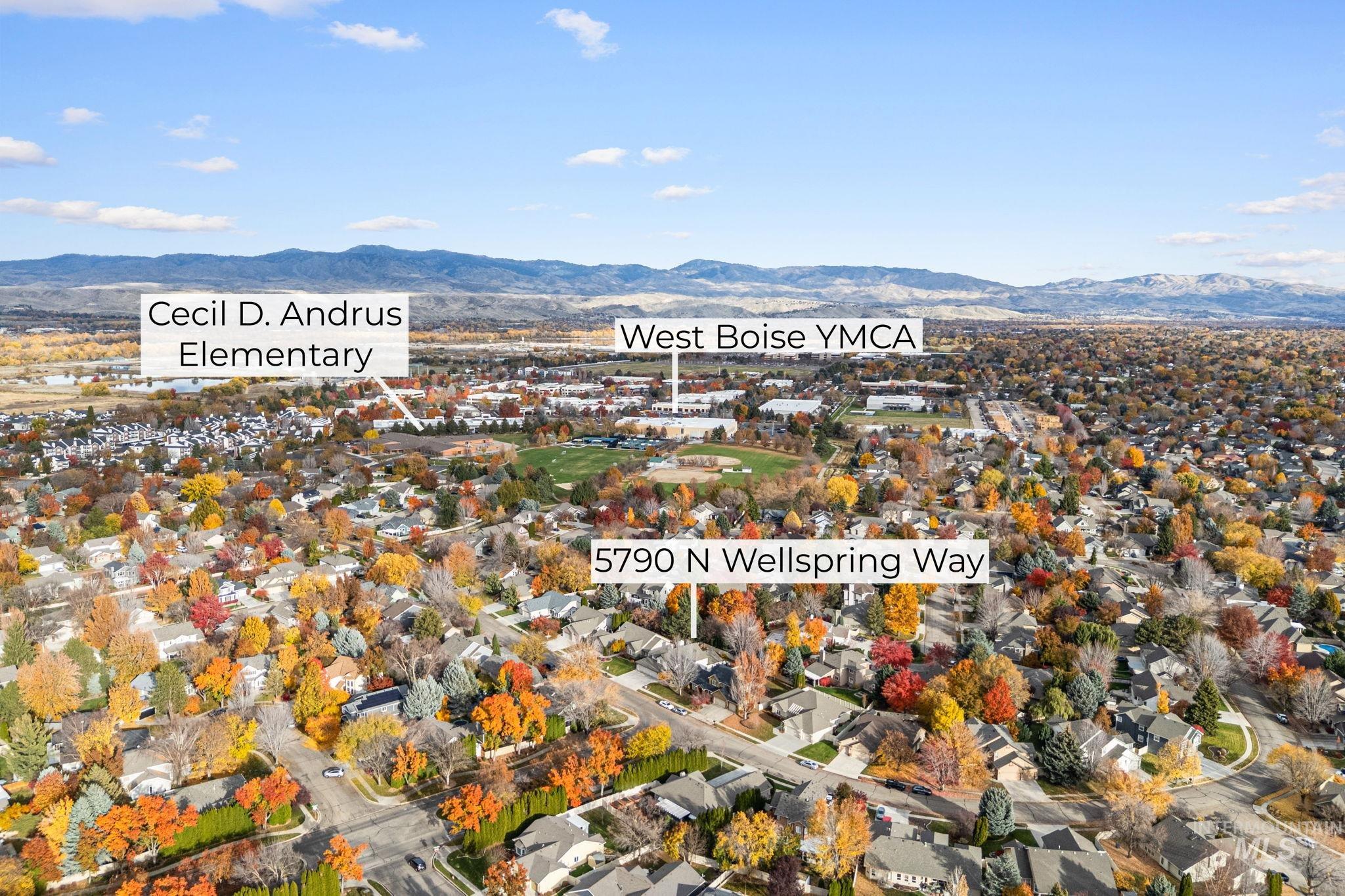 Aerial view of property and surrounding area featuring a mountainous background and nearby suburban area