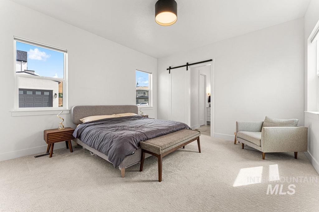 Light-filled room featuring plush carpet flooring, white walls, and a modern ceiling light fixture