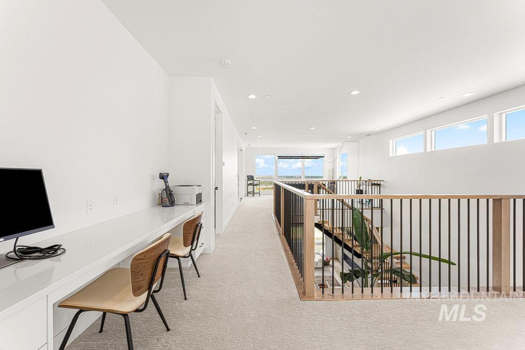 Upper-level hallway featuring a built-in white desk with integrated storage and recessed lighting