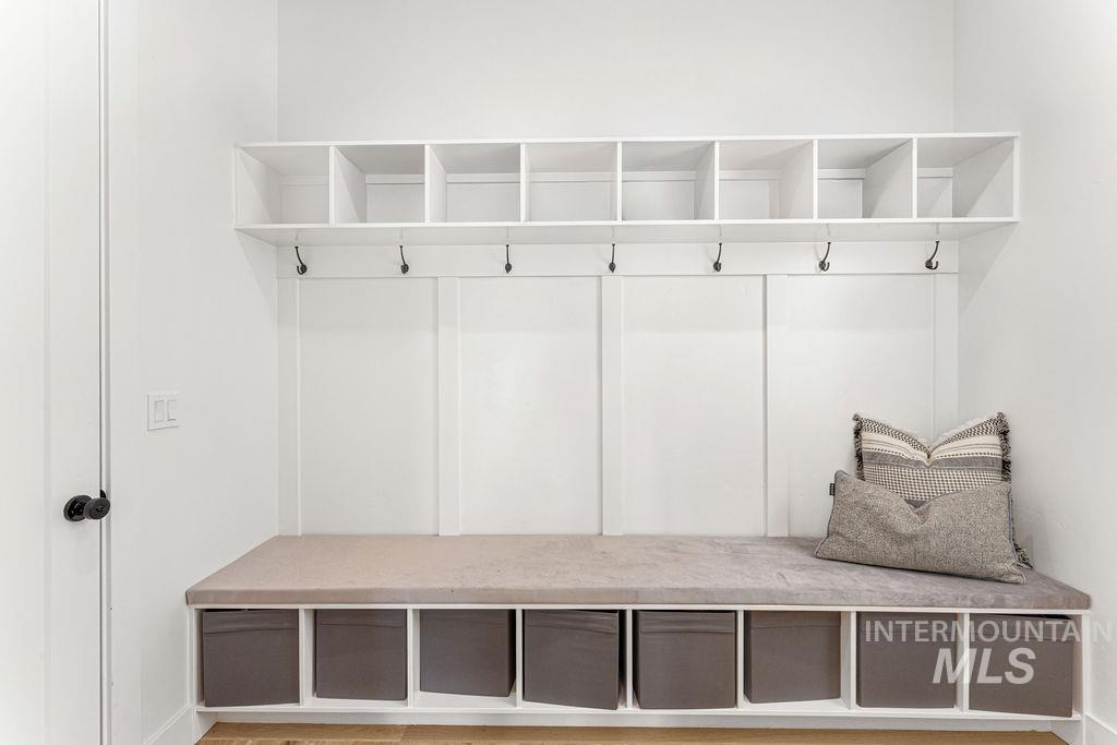 Built-in mudroom bench with cubby storage, upper shelving, and coat hooks