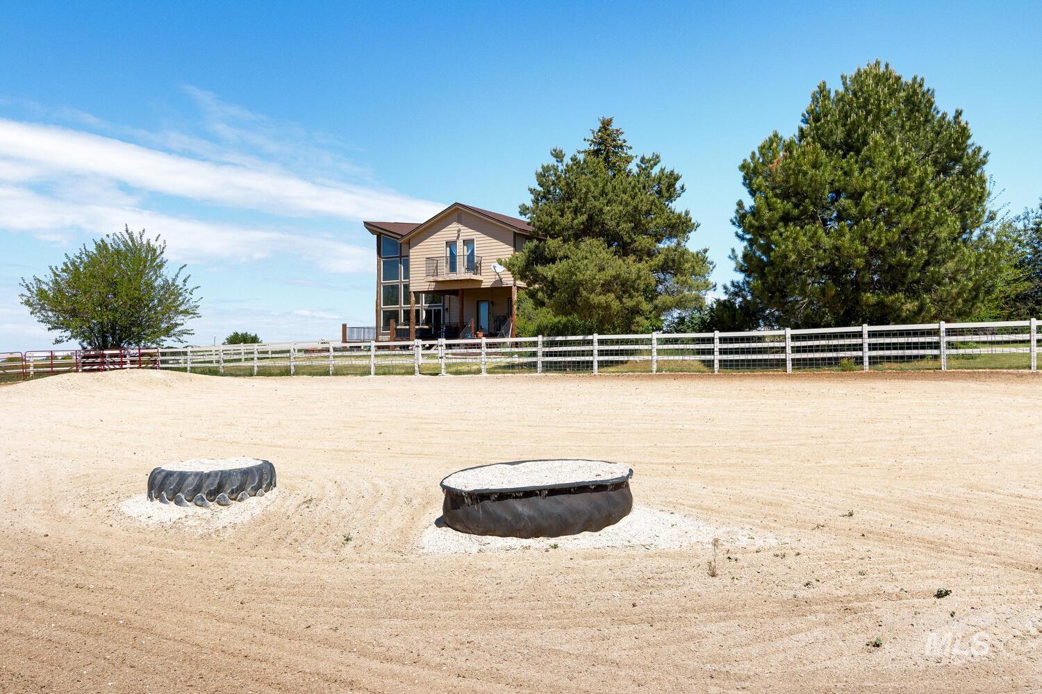 View of yard with an enclosed horse arena and a view of rural / pastoral area