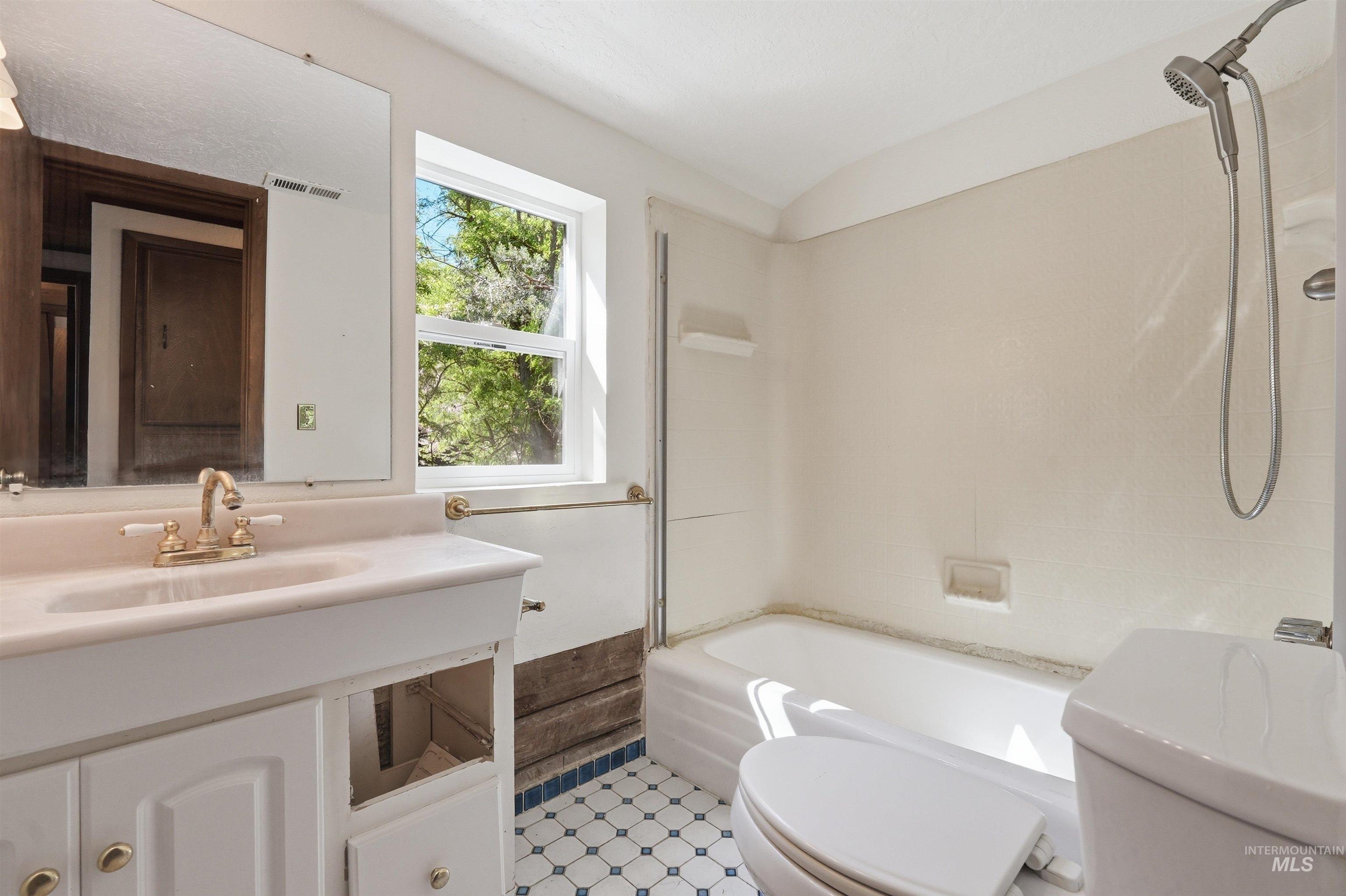 White vanity with integrated sink and brass-finish faucet