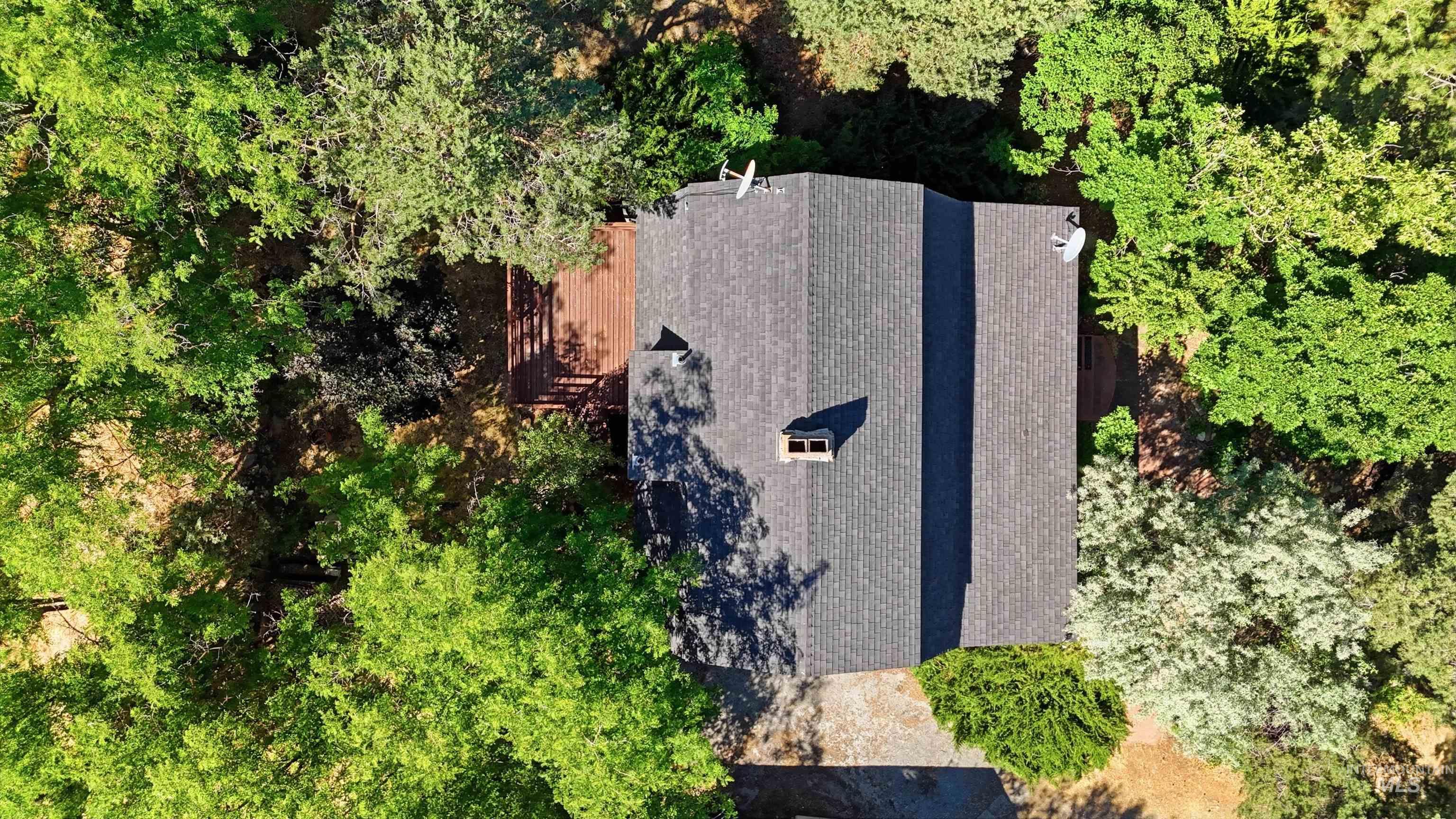 Asphalt shingle roof with a prominent chimney and satellite dishes