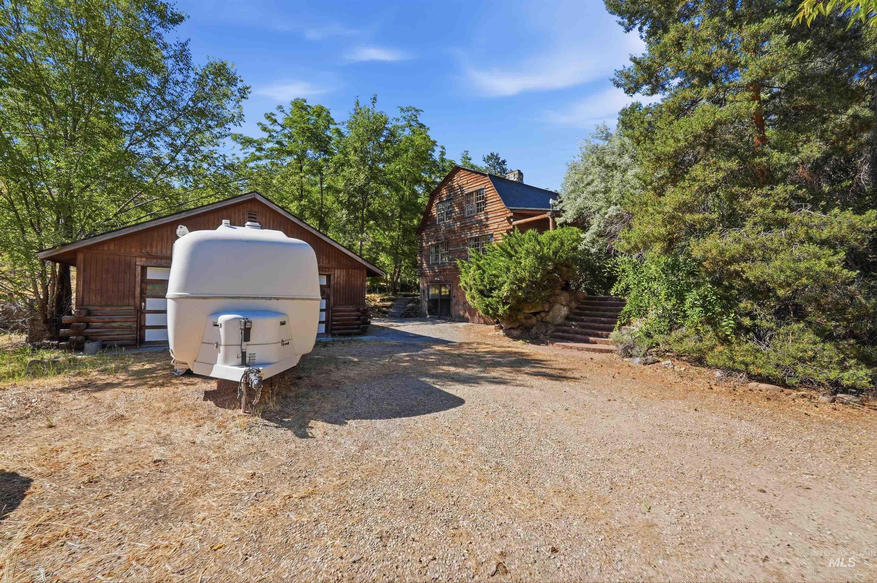 Detached wood-sided garage with two overhead doors
