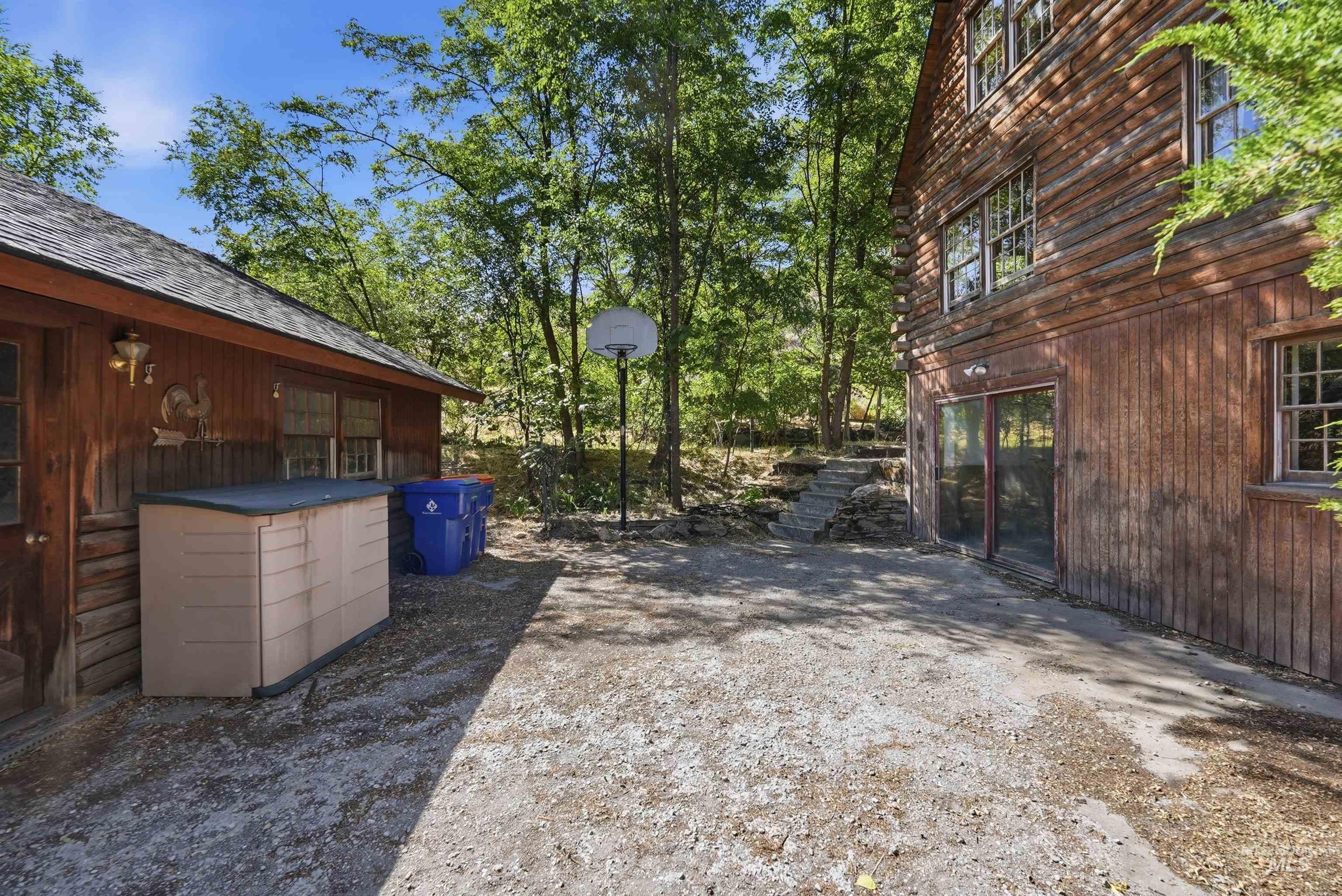Rustic wood-sided dwelling featuring multiple windows and sliding glass doors