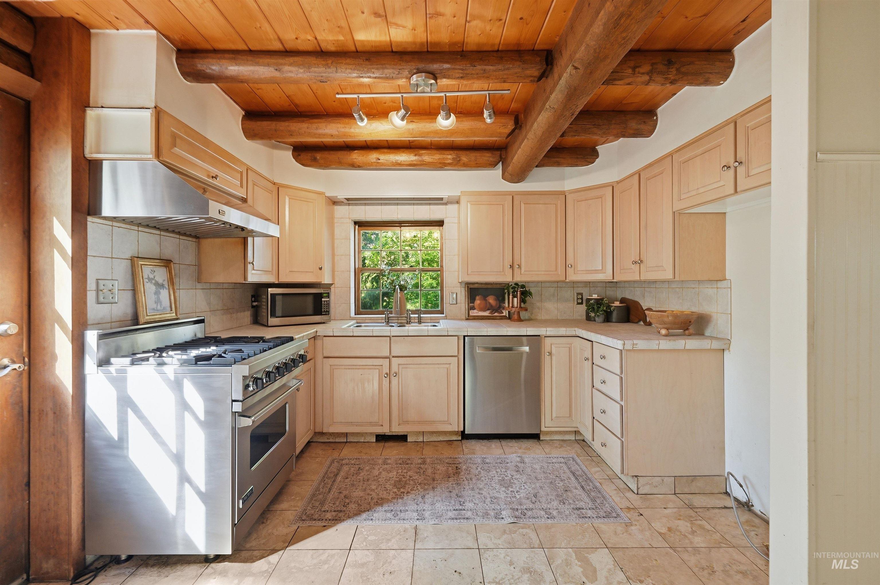 Kitchen featuring a wood plank ceiling with exposed log beams, recessed lighting, and tile flooring