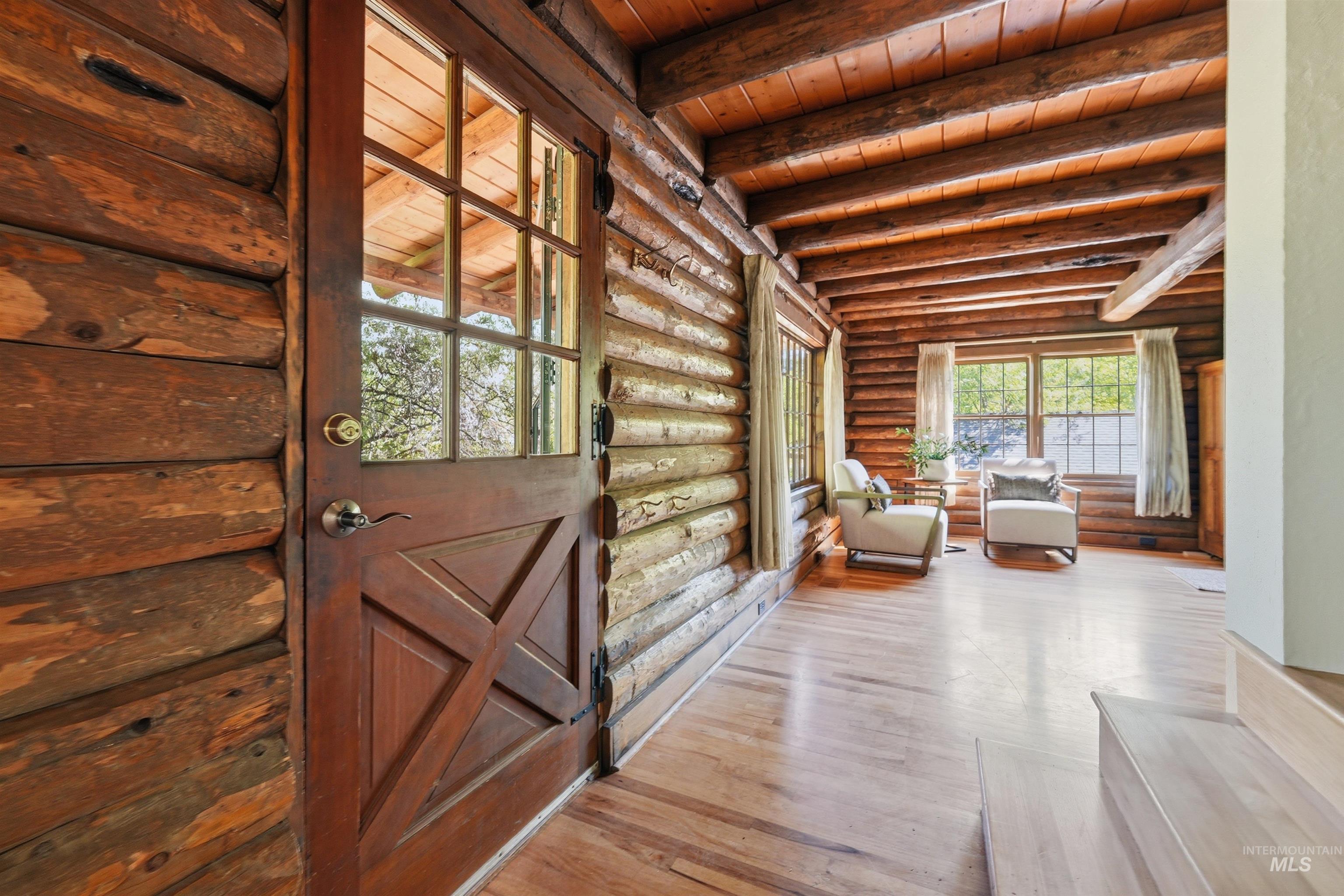 Rustic log cabin interior featuring exposed log walls and ceiling beams