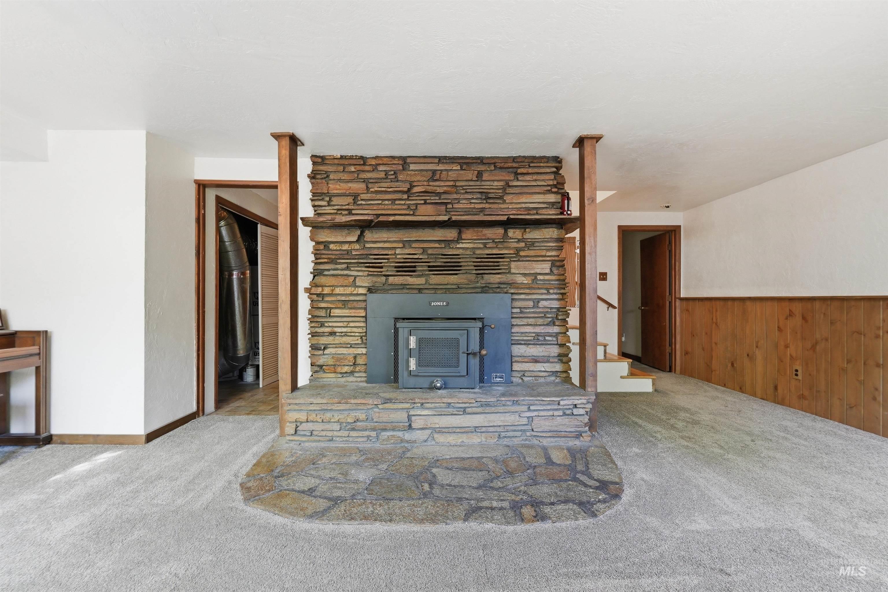 Stone-clad fireplace with a wood-burning insert and a natural stone hearth