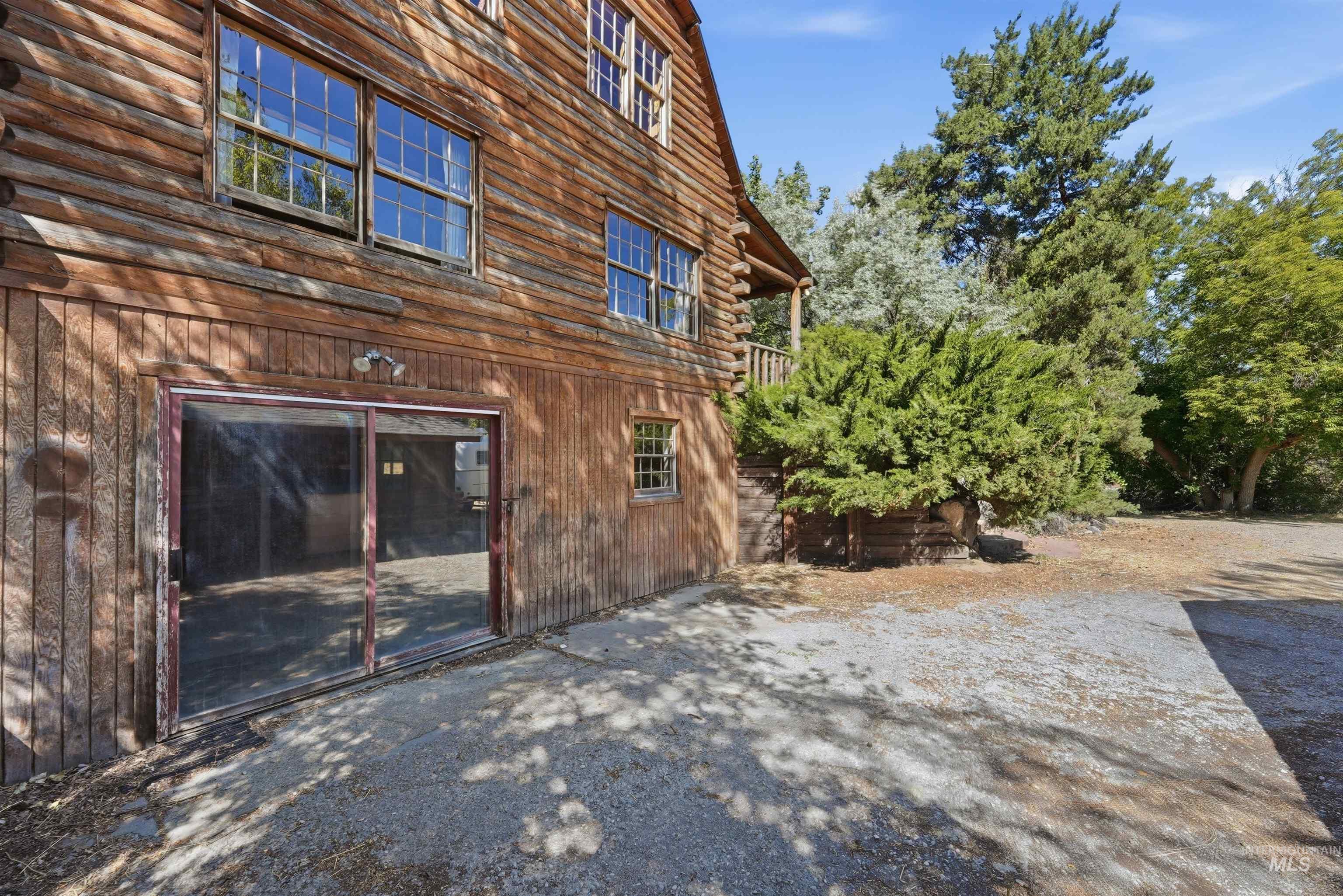 Wood-sided building with multiple windows and a ground-level sliding glass door