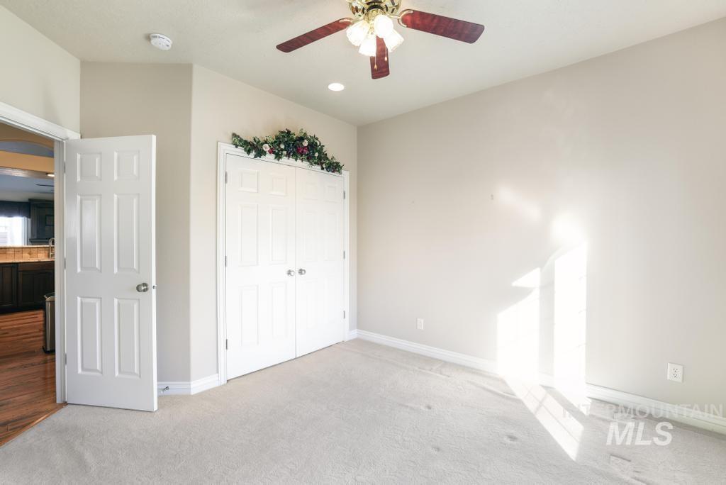 Unfurnished bedroom with carpet, a closet, a ceiling fan, and recessed lighting