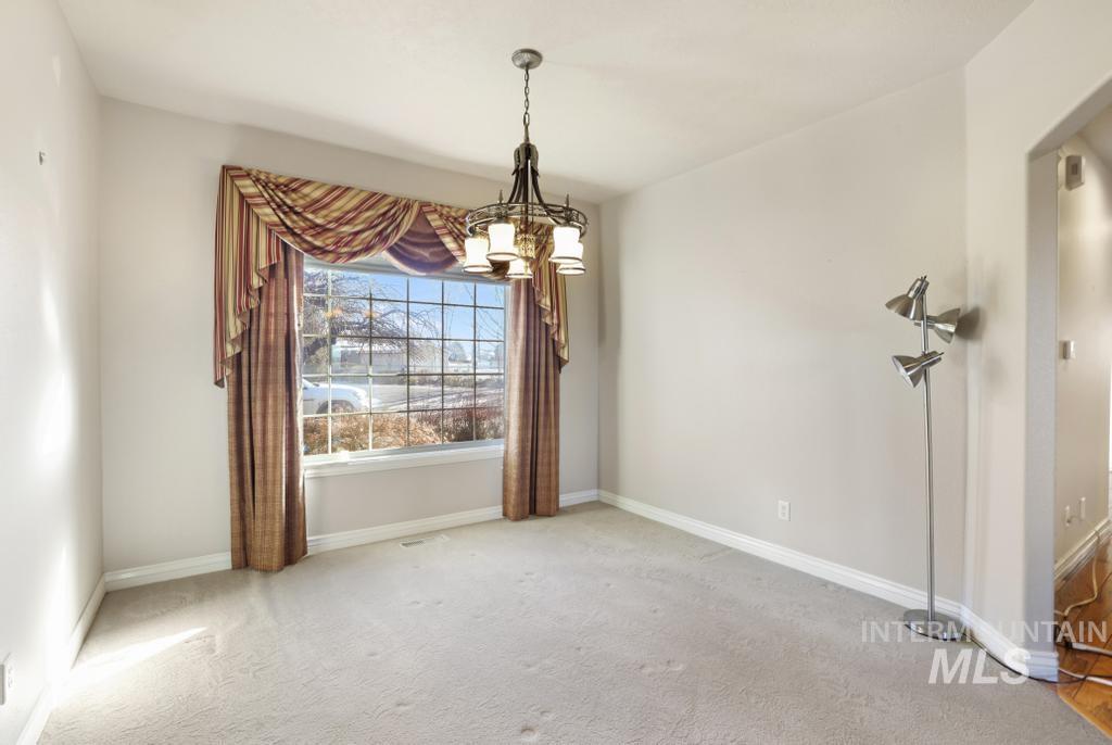Unfurnished room with carpet floors and a chandelier