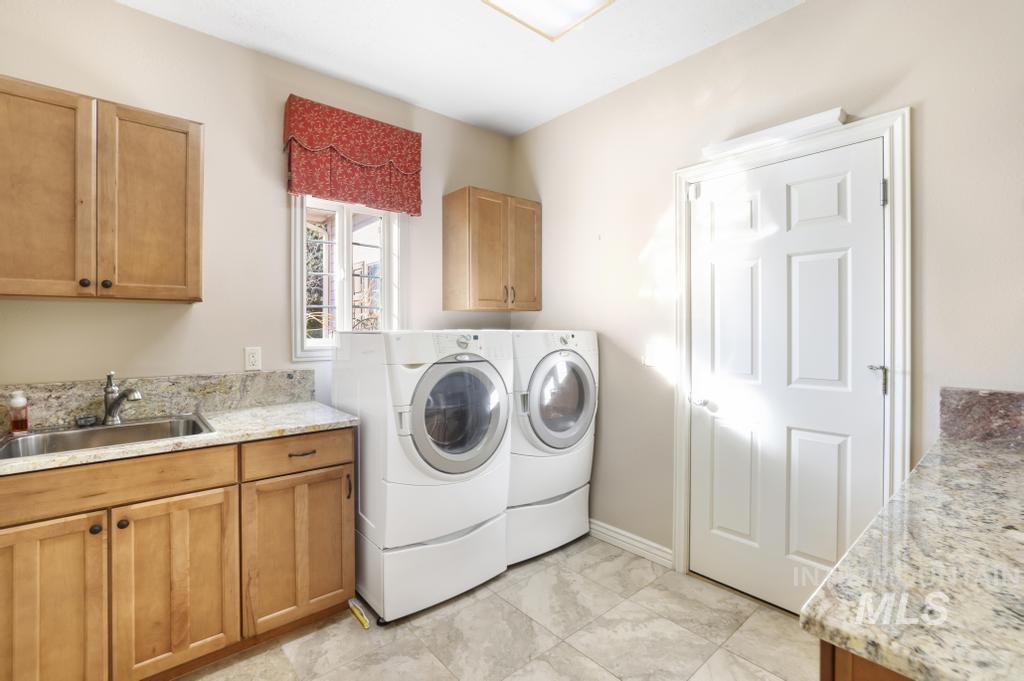 Washroom featuring cabinet space and washer and clothes dryer