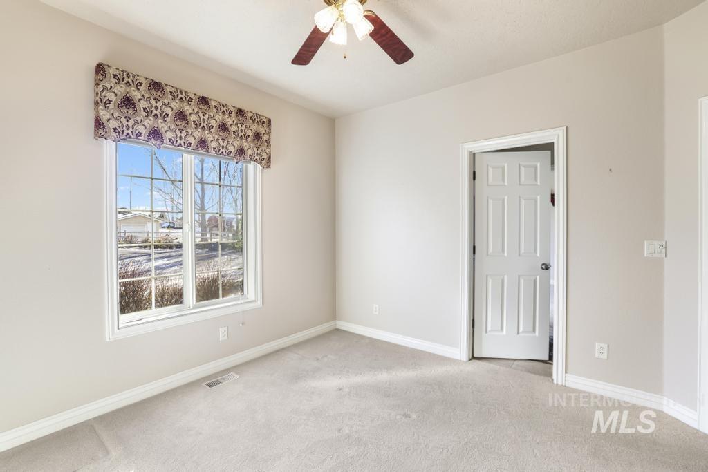 Unfurnished room featuring carpet floors and a ceiling fan