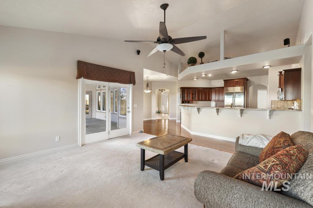 Living room with lofted ceiling and a ceiling fan