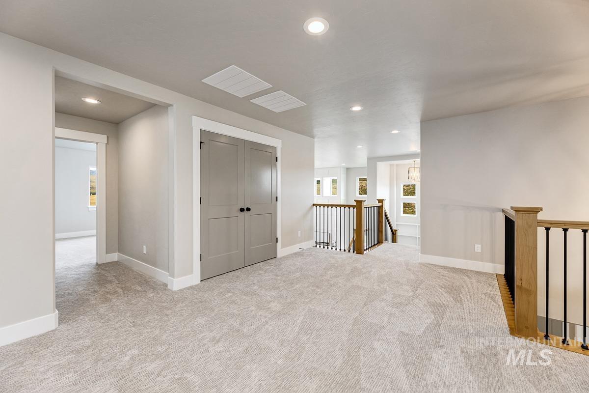 Corridor with recessed lighting, light carpet, and an upstairs landing