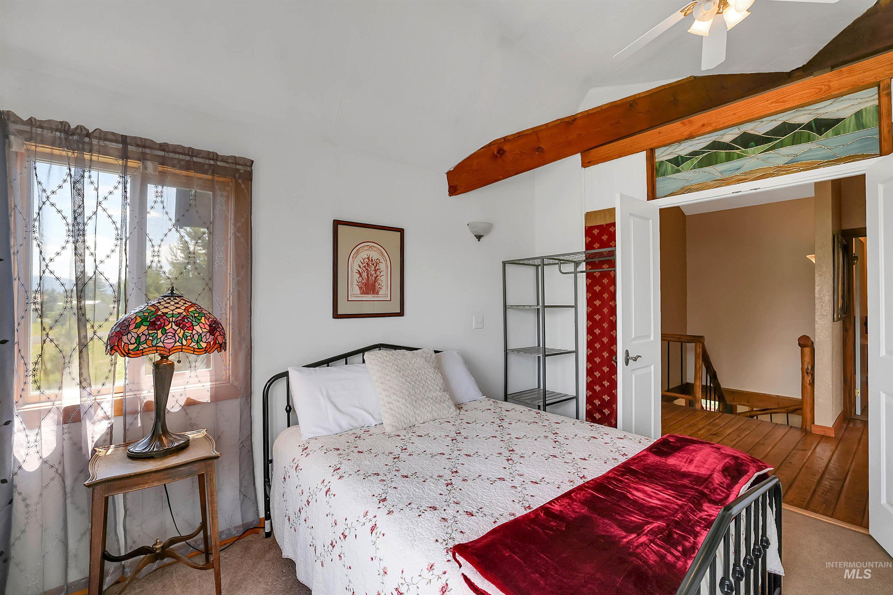 Carpeted bedroom featuring lofted ceiling and ceiling fan