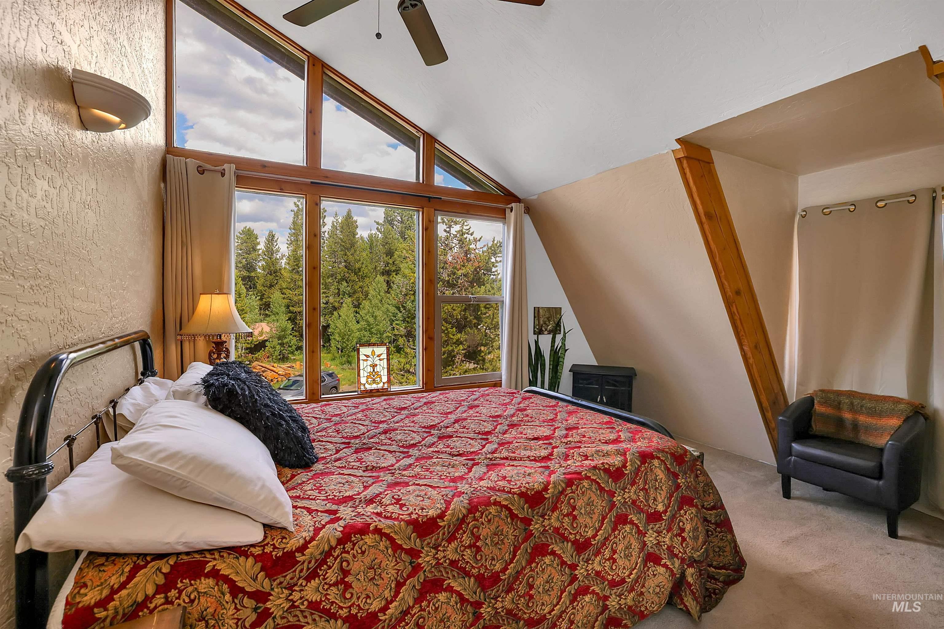 Bedroom with lofted ceiling, carpet floors, and a ceiling fan