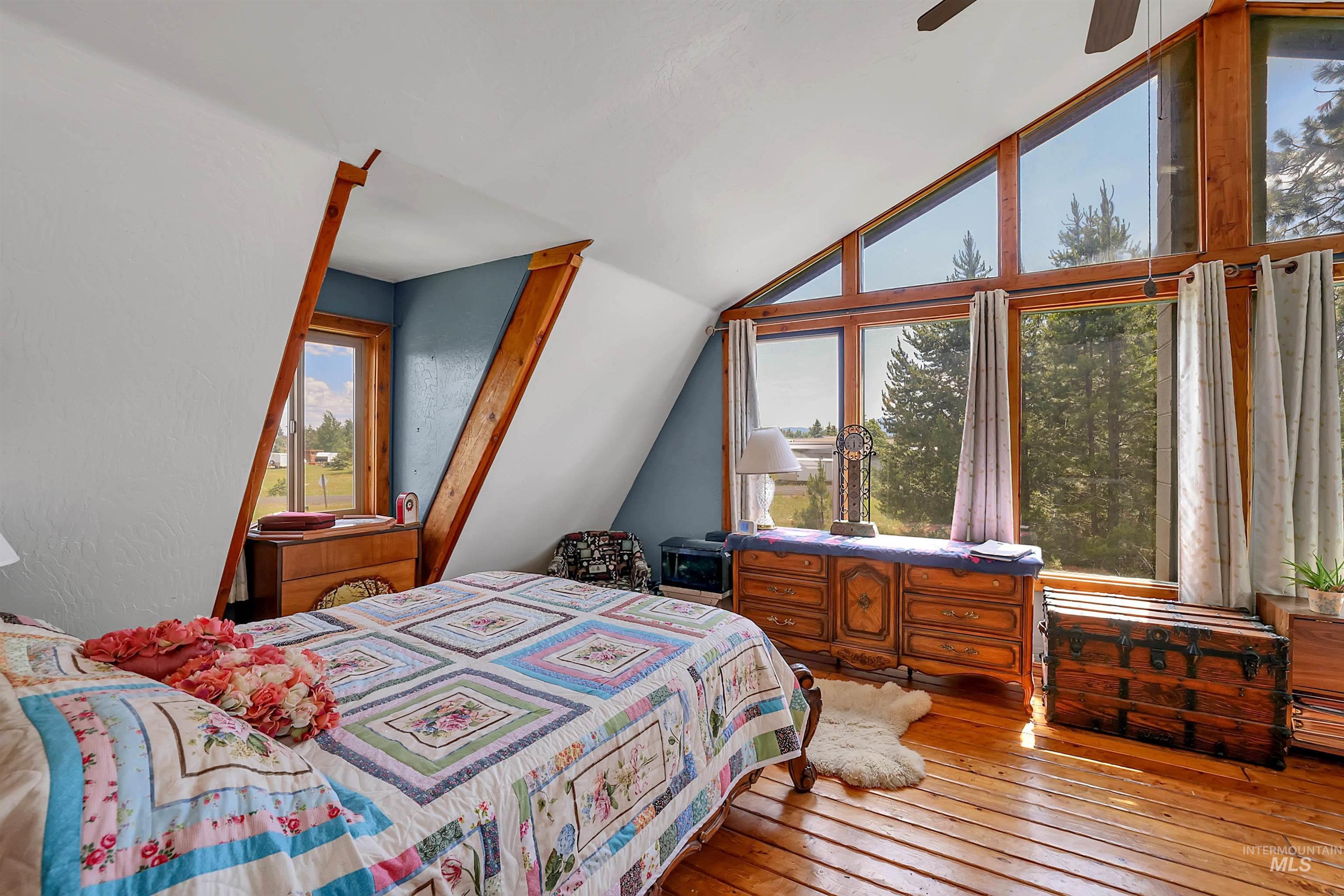 Bedroom featuring lofted ceiling, wood-type flooring, and a ceiling fan