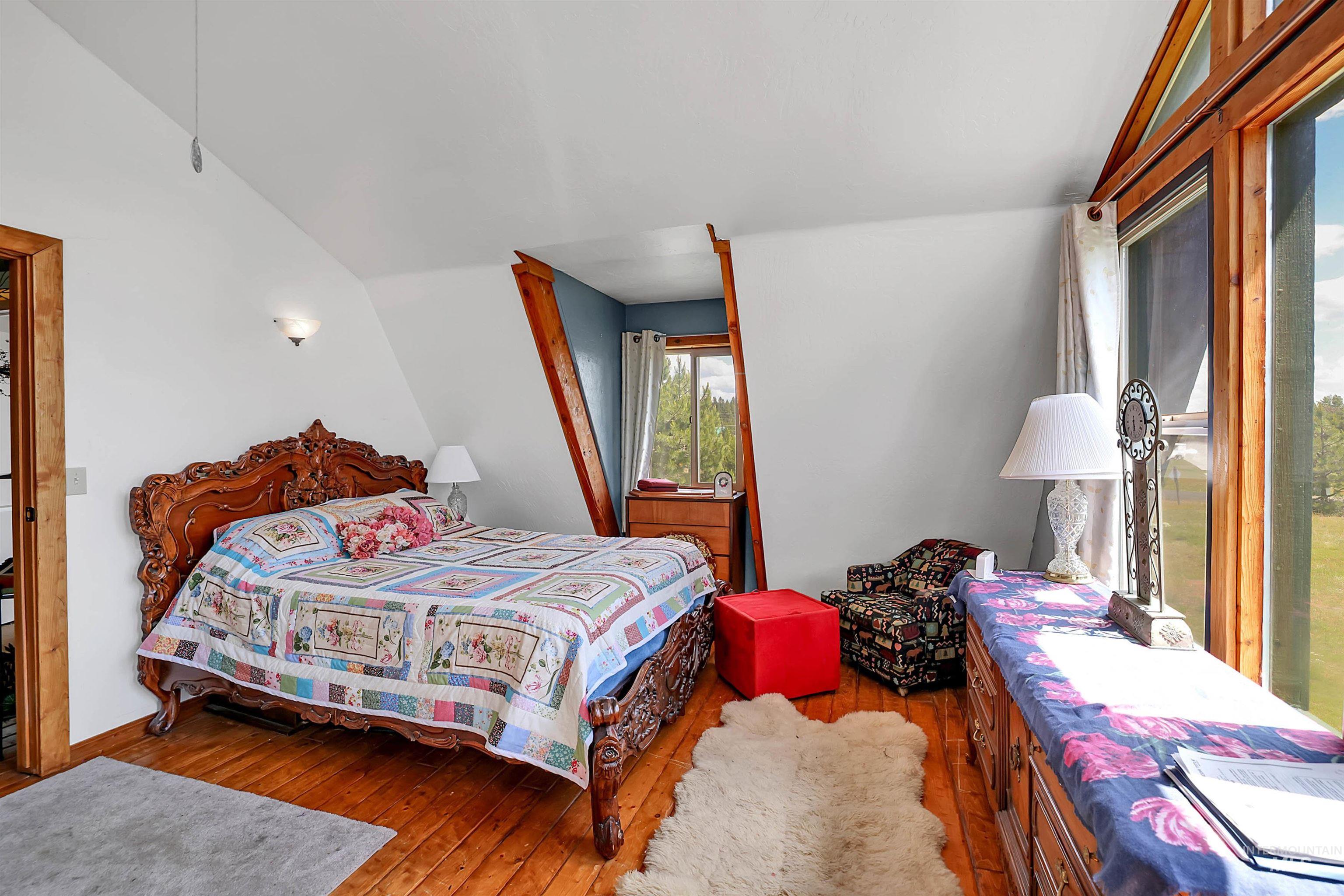 Bedroom with hardwood / wood-style floors and lofted ceiling