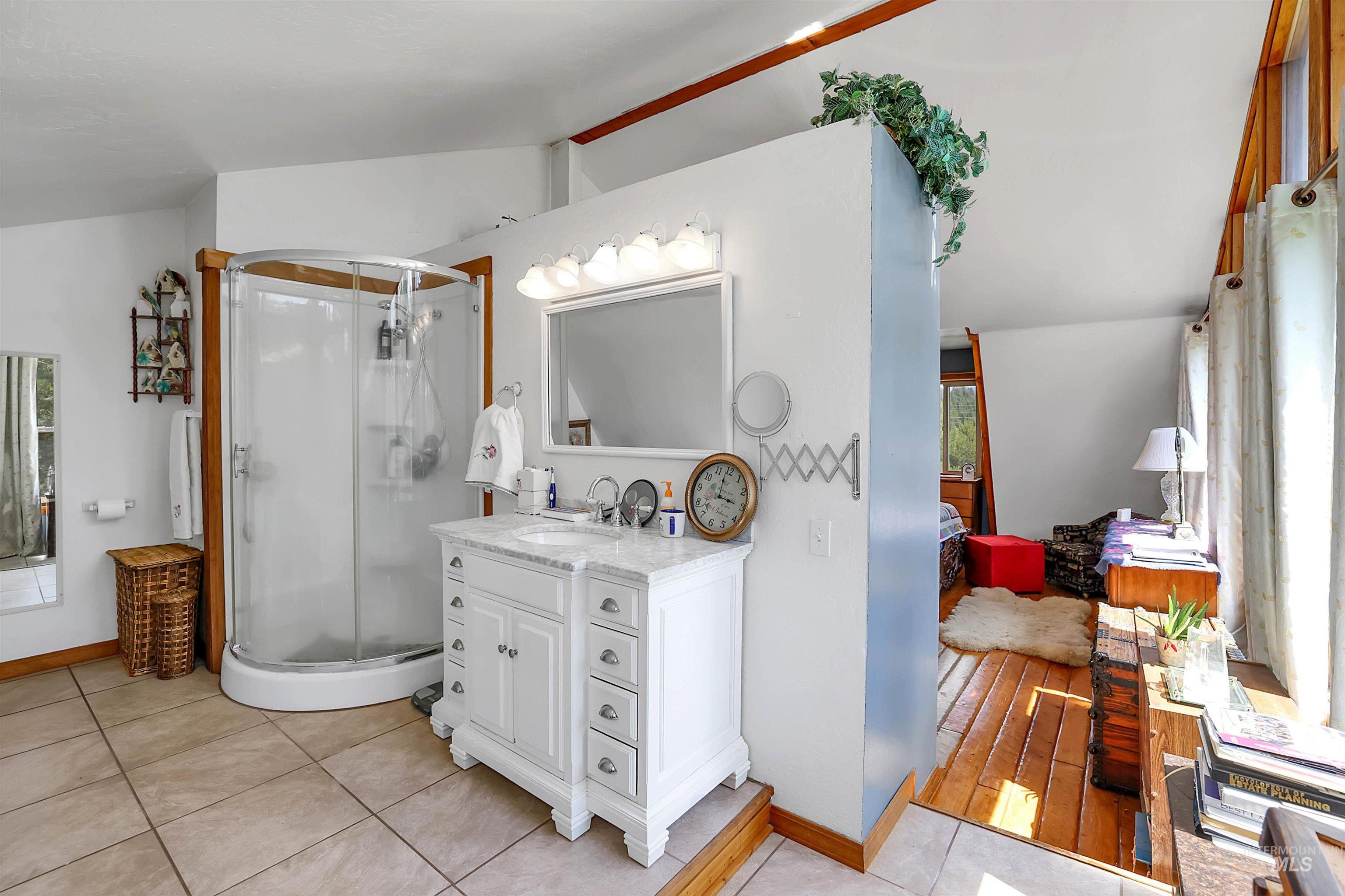 Ensuite bathroom featuring vanity, a stall shower, and tile patterned floors
