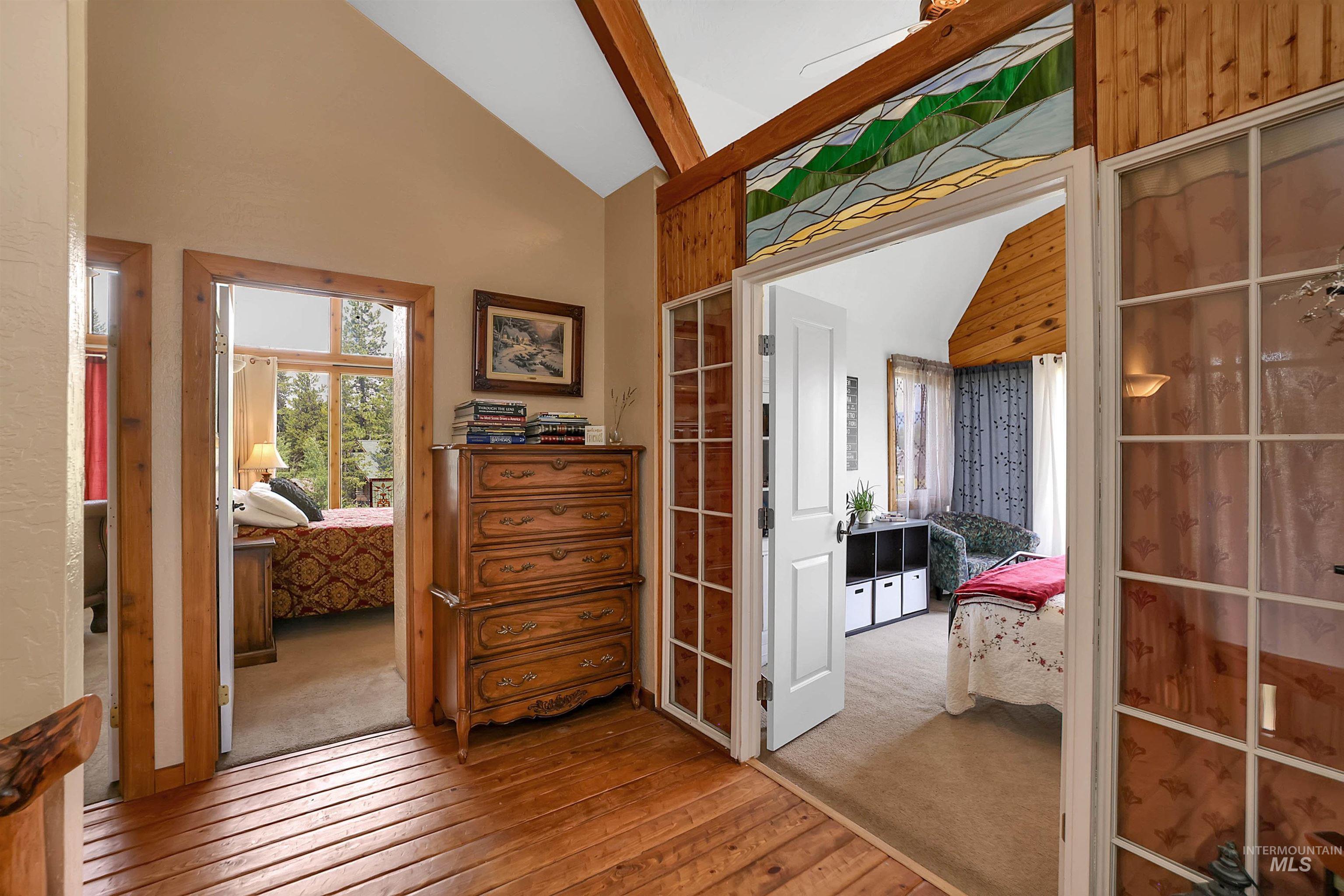 Hallway featuring hardwood / wood-style flooring, high vaulted ceiling, and beamed ceiling
