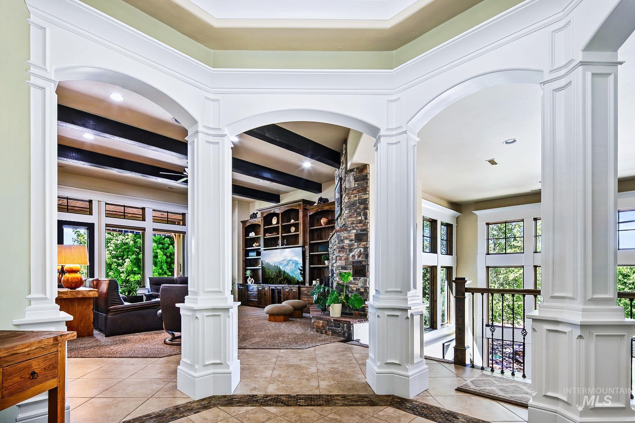Stunning open-concept entryway with dramatic archways, detailed millwork, and sweeping views into the great room