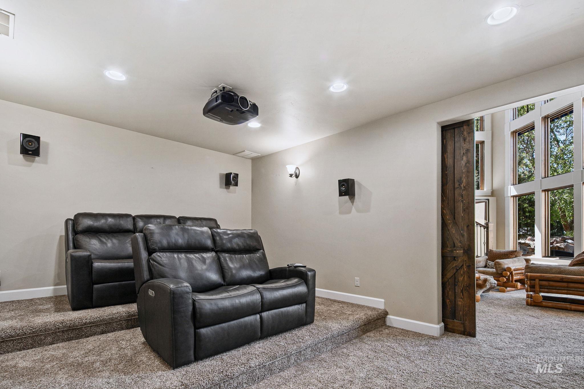 Private theater room complete with an 84-inch screen, surround sound system, and tiered seating platform for an immersive at-home movie experience