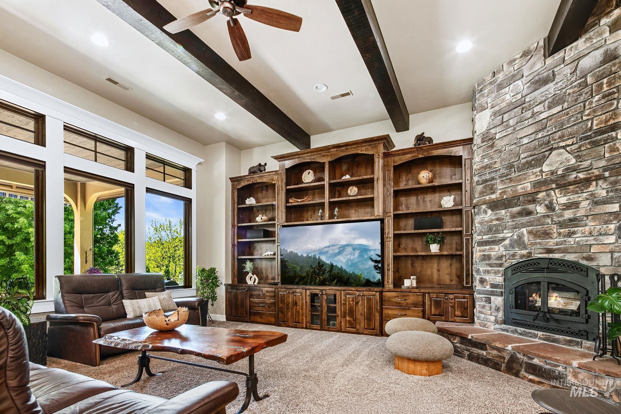 Designed for comfort and entertaining, this spacious living area offers vaulted ceilings, rich wood accents, and picturesque natural light
