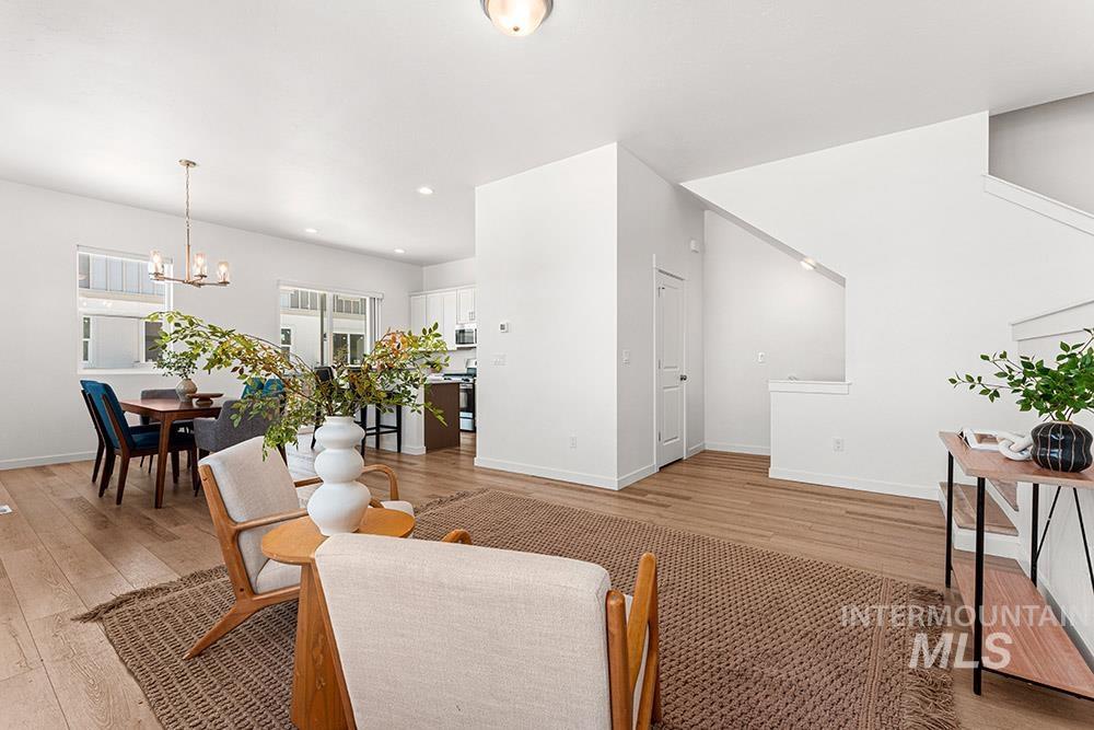 Living area featuring light wood-type flooring, a chandelier, and recessed lighting