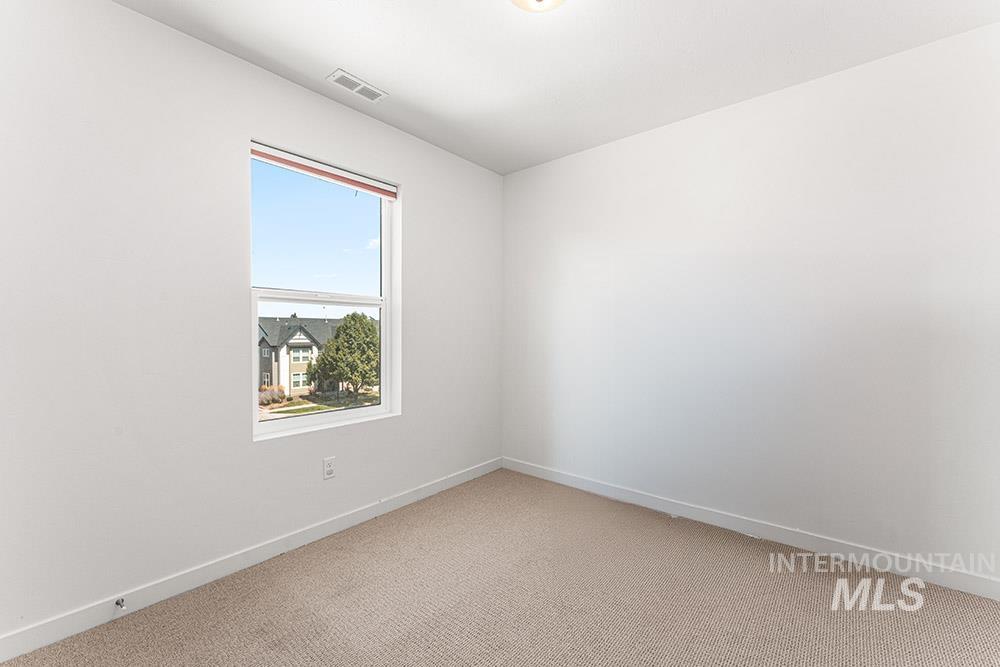 Empty room featuring light carpet and baseboards