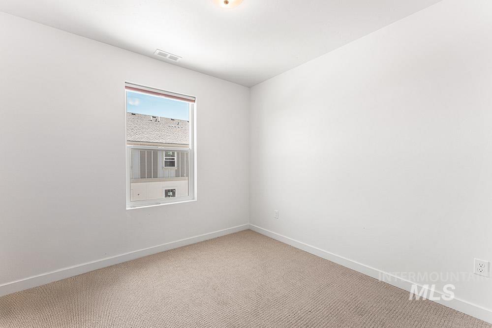 Spare room featuring carpet floors and baseboards