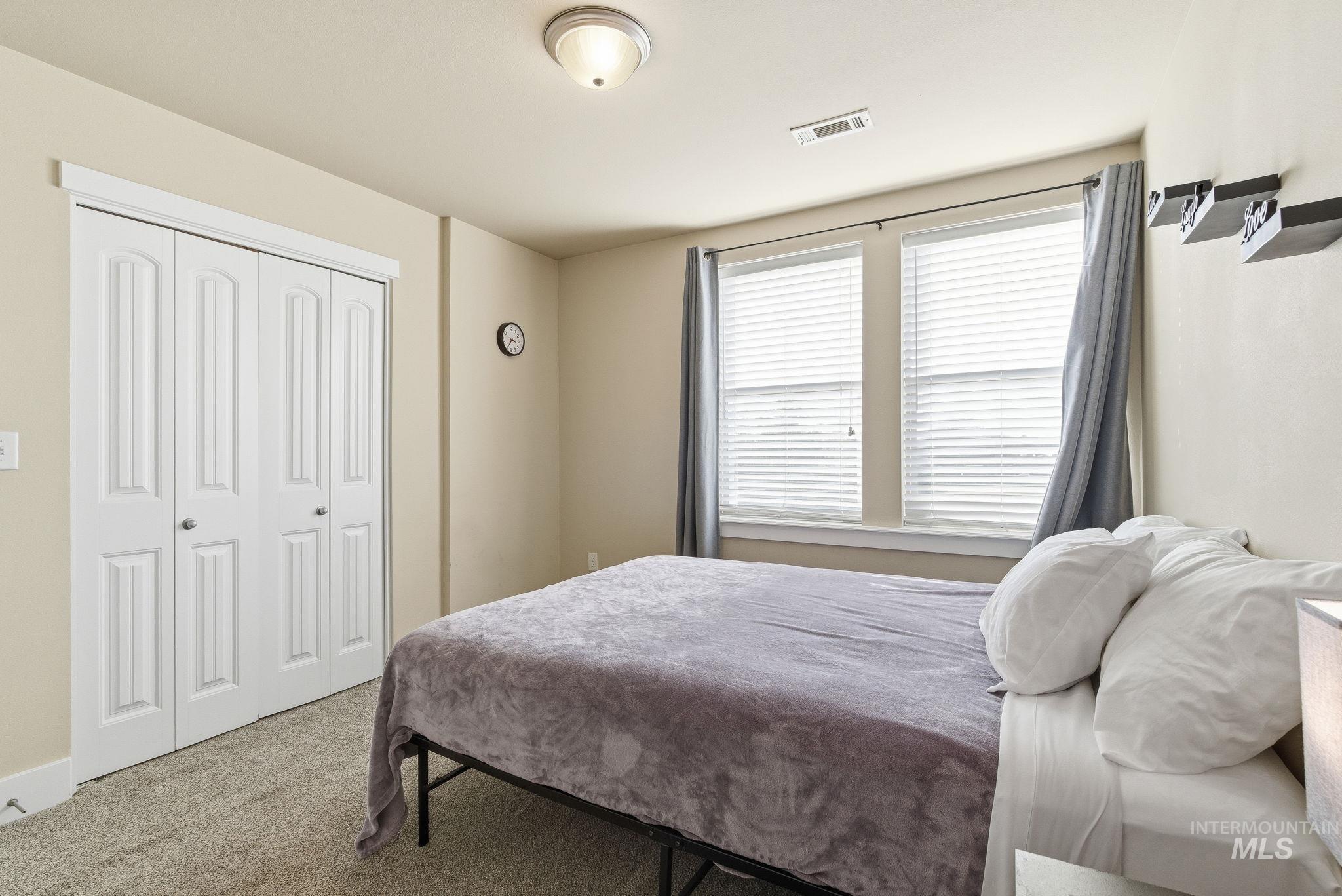 Carpeted bedroom with a closet