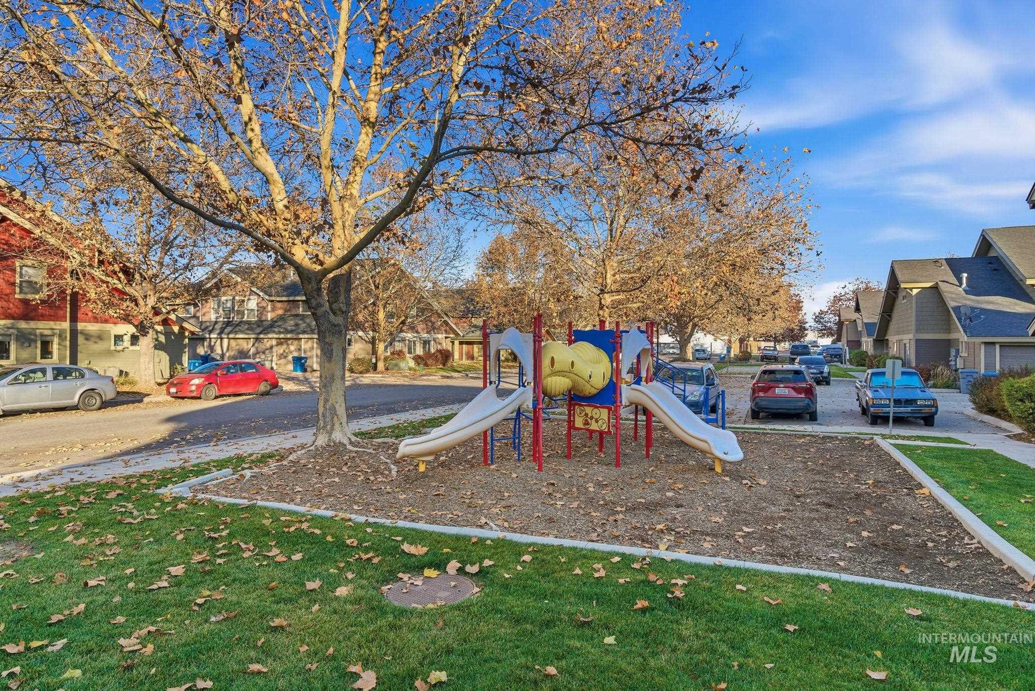 Community playground with a residential view and a yard