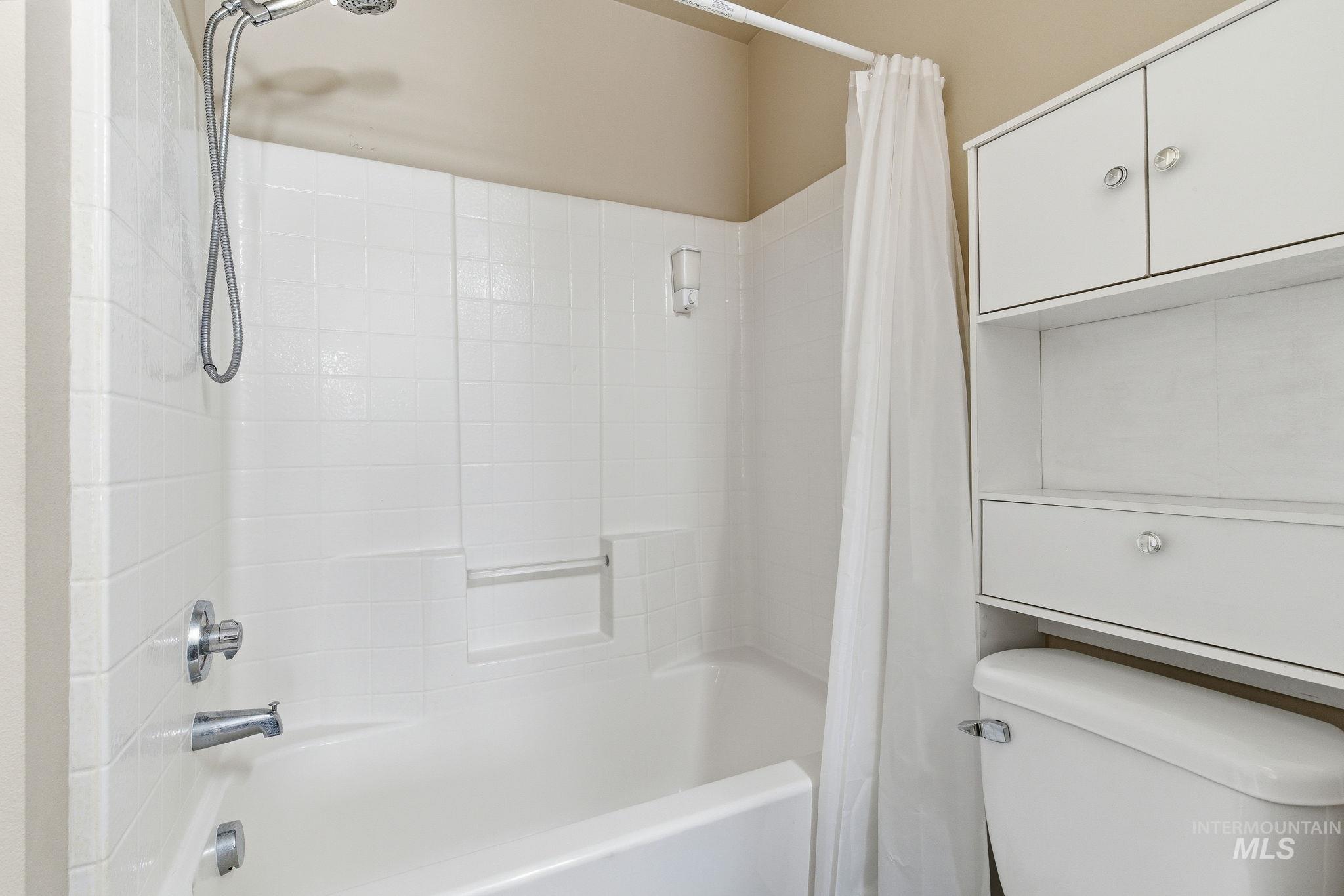 Bathroom featuring shower / bath combo and toilet