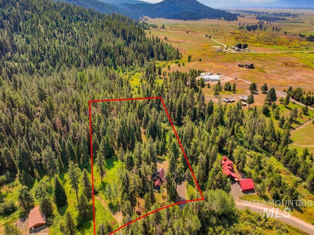 Aerial overview of property's location with property parcel outlined and mountains