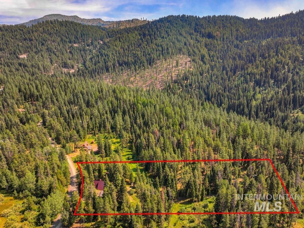 Aerial overview of property's location featuring property parcel outlined and a forest