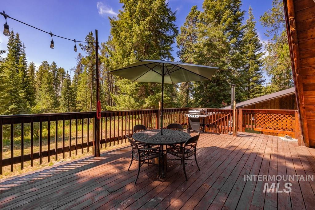 Wooden deck with outdoor dining space and grilling area